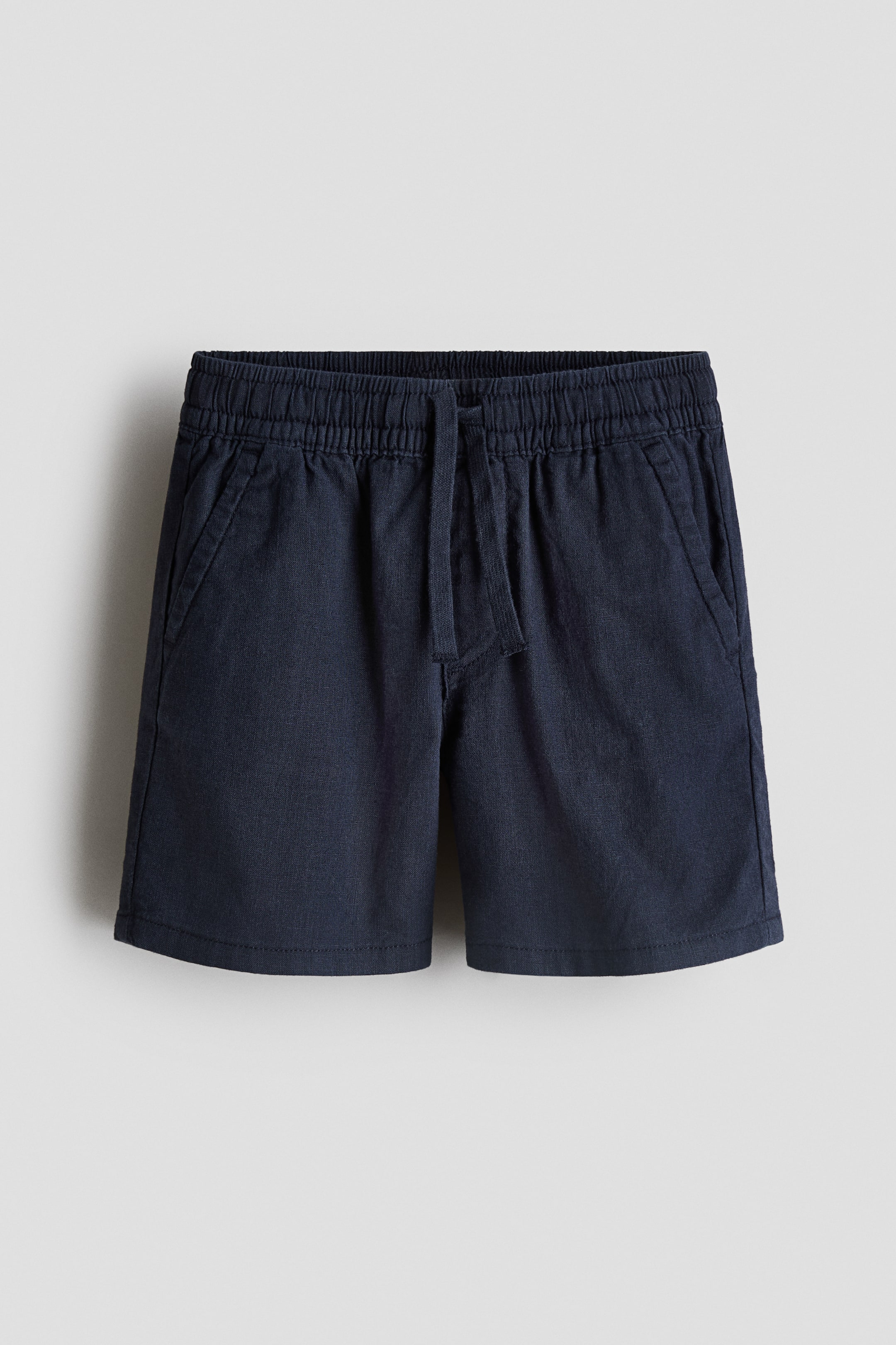 View larger image: The dark blue shorts are presenting from the front, featuring an elasticated waistband with a drawstring and two diagonal slash pockets.