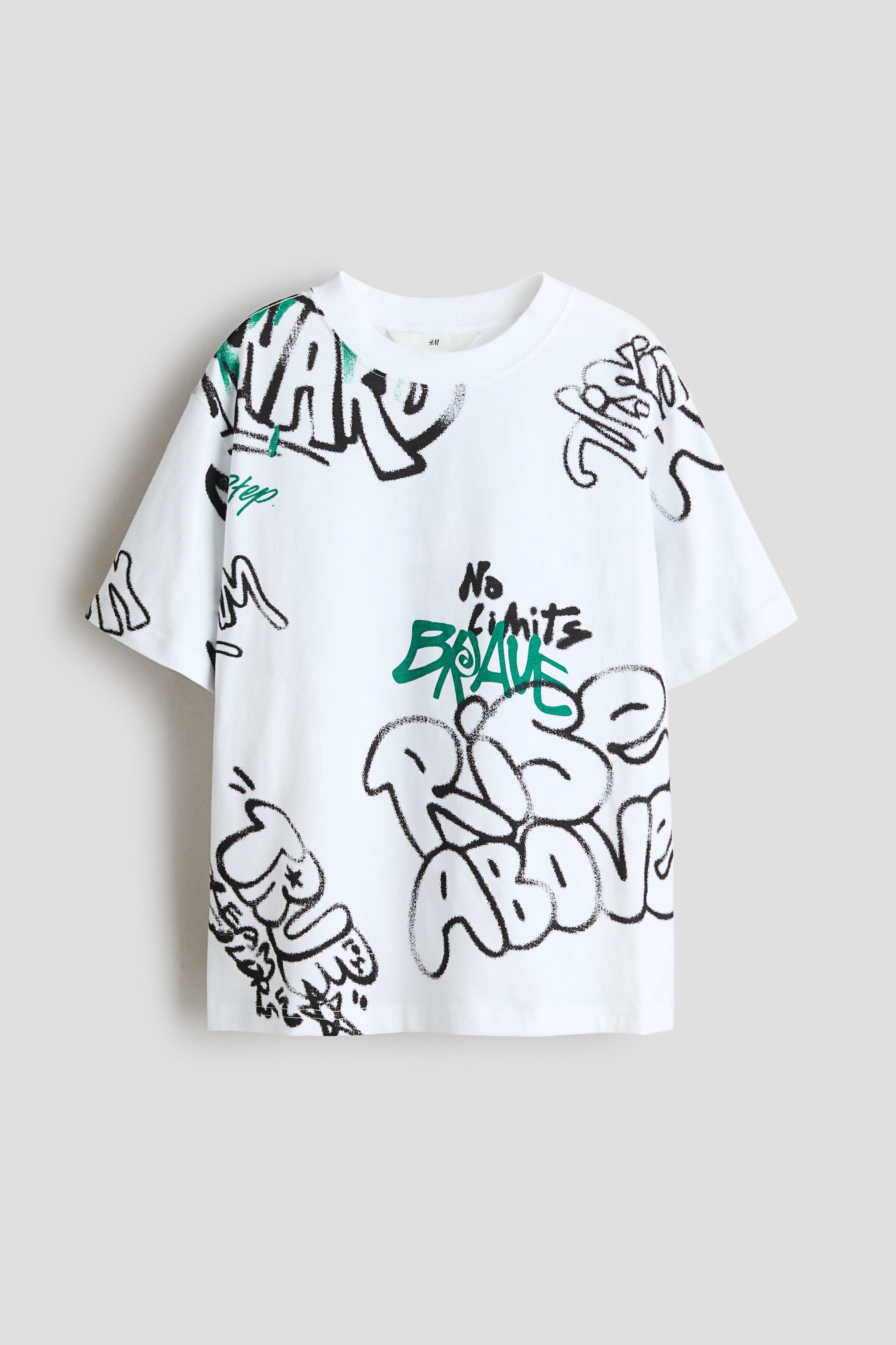 View larger image: A loose-fit T-shirt in printed cotton jersey with a ribbed trim around the neckline and dropped shoulders is shown FRONT facing. It features black and green graffiti-style prints across its white surface.