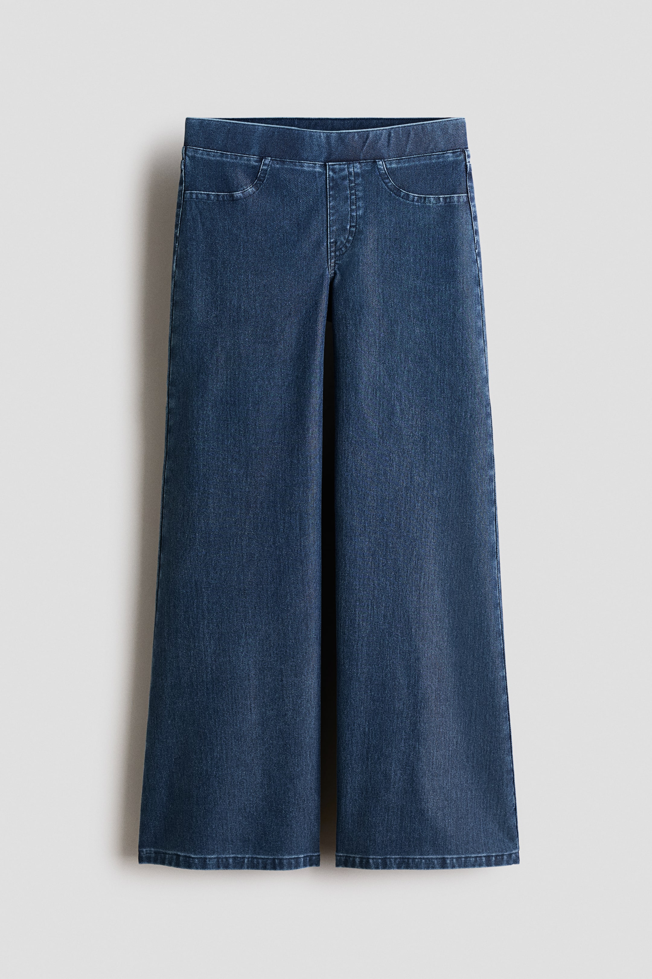 Se større billede: Mørkeblå denim bukser med brede ben, der har en elastisk talje, falske forlommer og en syet, imiteret gylp detalje.