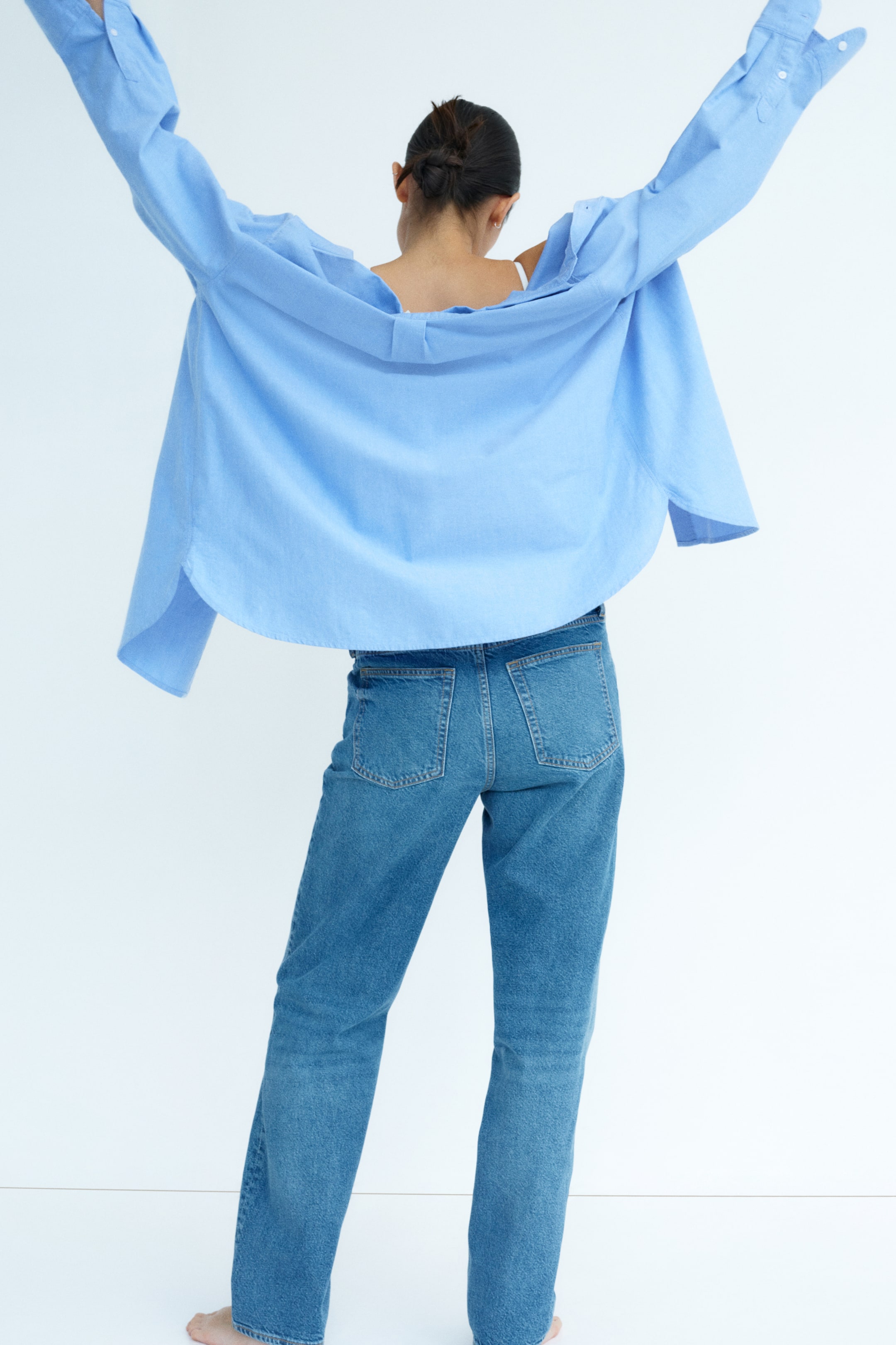 Agrandir l'image: Jean en denim avec taille basse, jambe droite et poches arrière portés par le mannequin. Le jean s'ajuste de manière régulière de la taille à la hanche, avec une coupe droite de la cuisse à l'ourlet, atteignant le haut du pied.