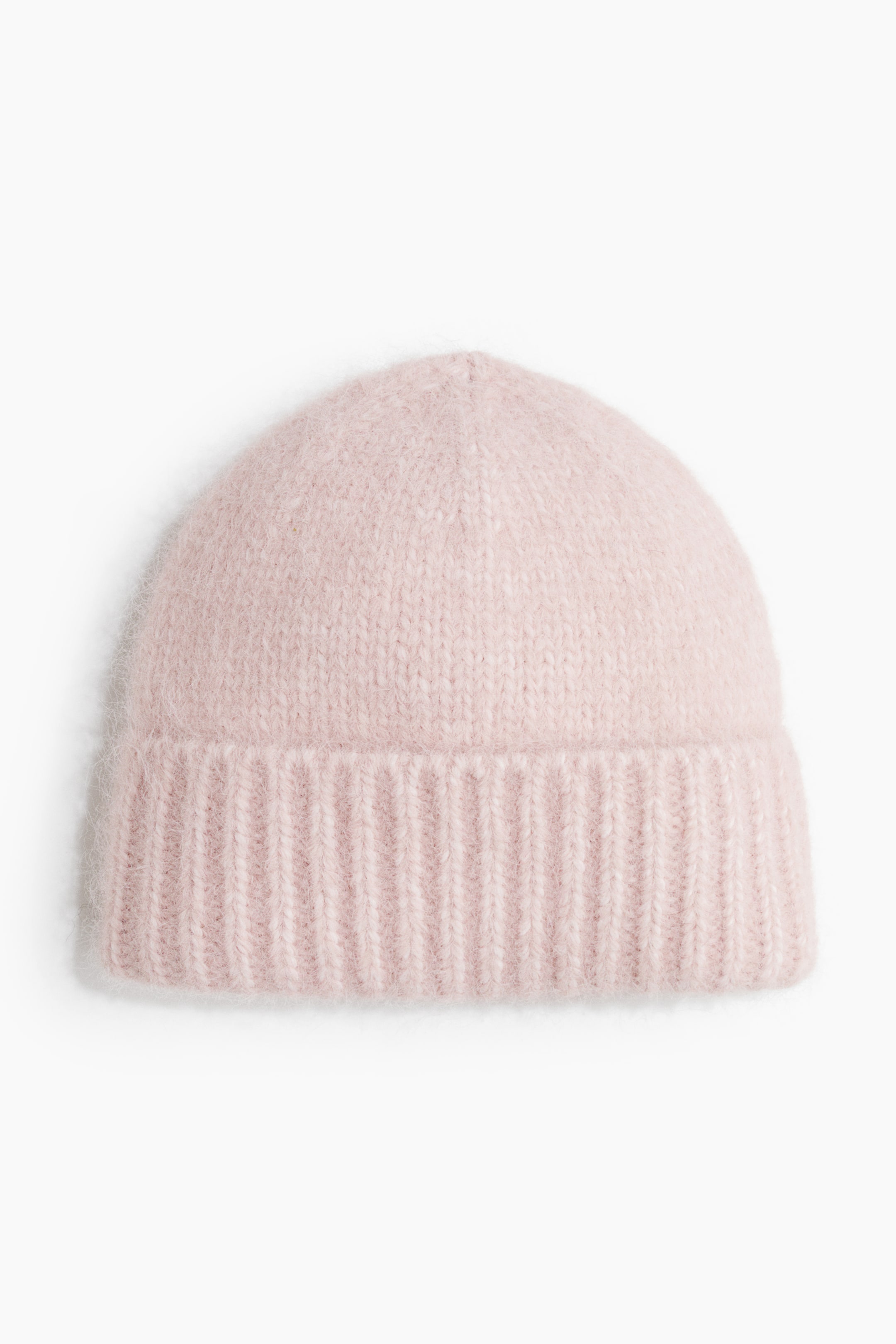 View larger image: A light pink beanie is facing the front, featuring a soft, fuzzy knit texture and a wide ribbed cuff.