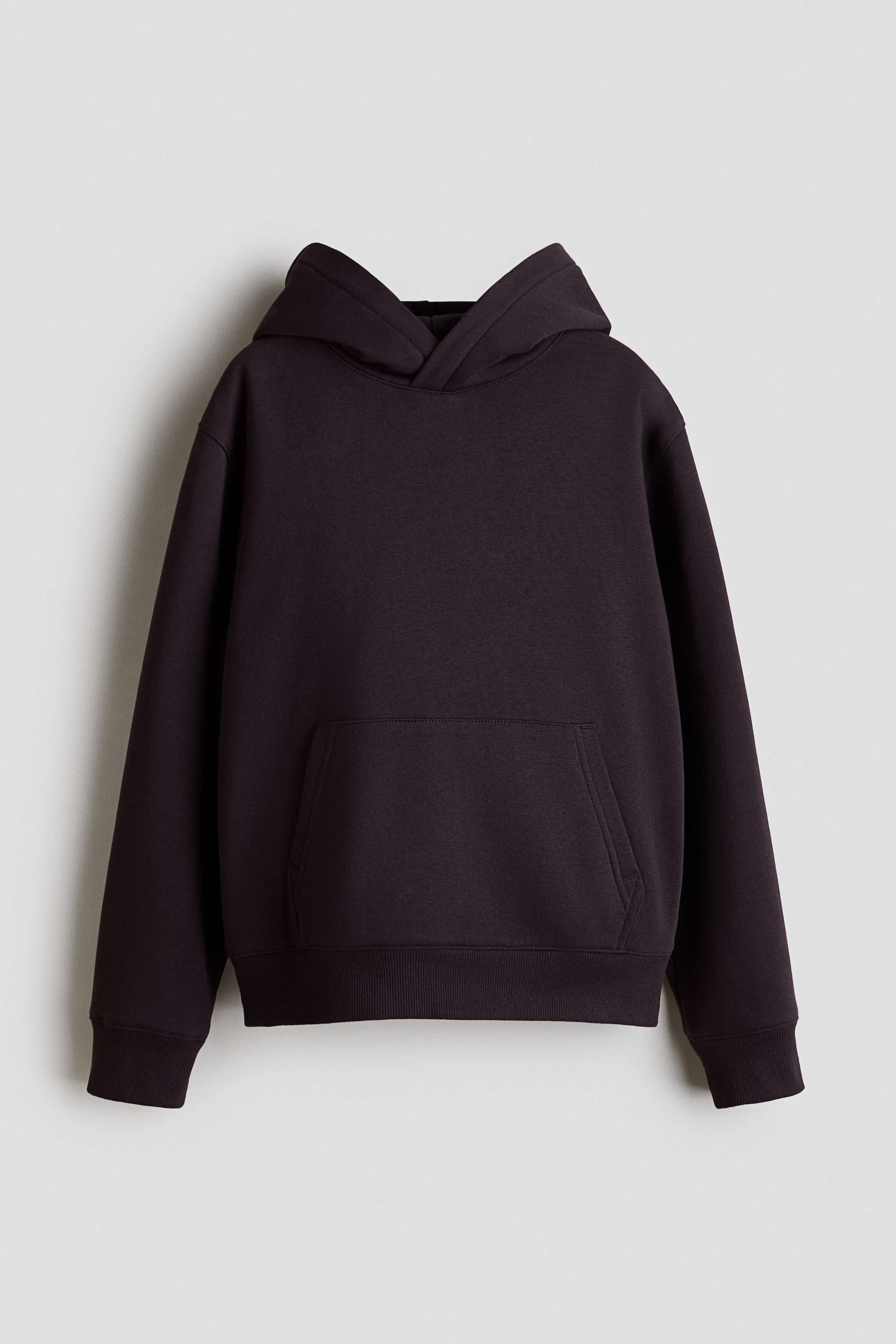 View larger image: A dark purple hoodie is shown from the front, featuring a jersey-lined hood with a wrapover front, gently dropped shoulders, and long sleeves. A kangaroo pocket is visible on the front, and ribbing details the cuffs and hem.