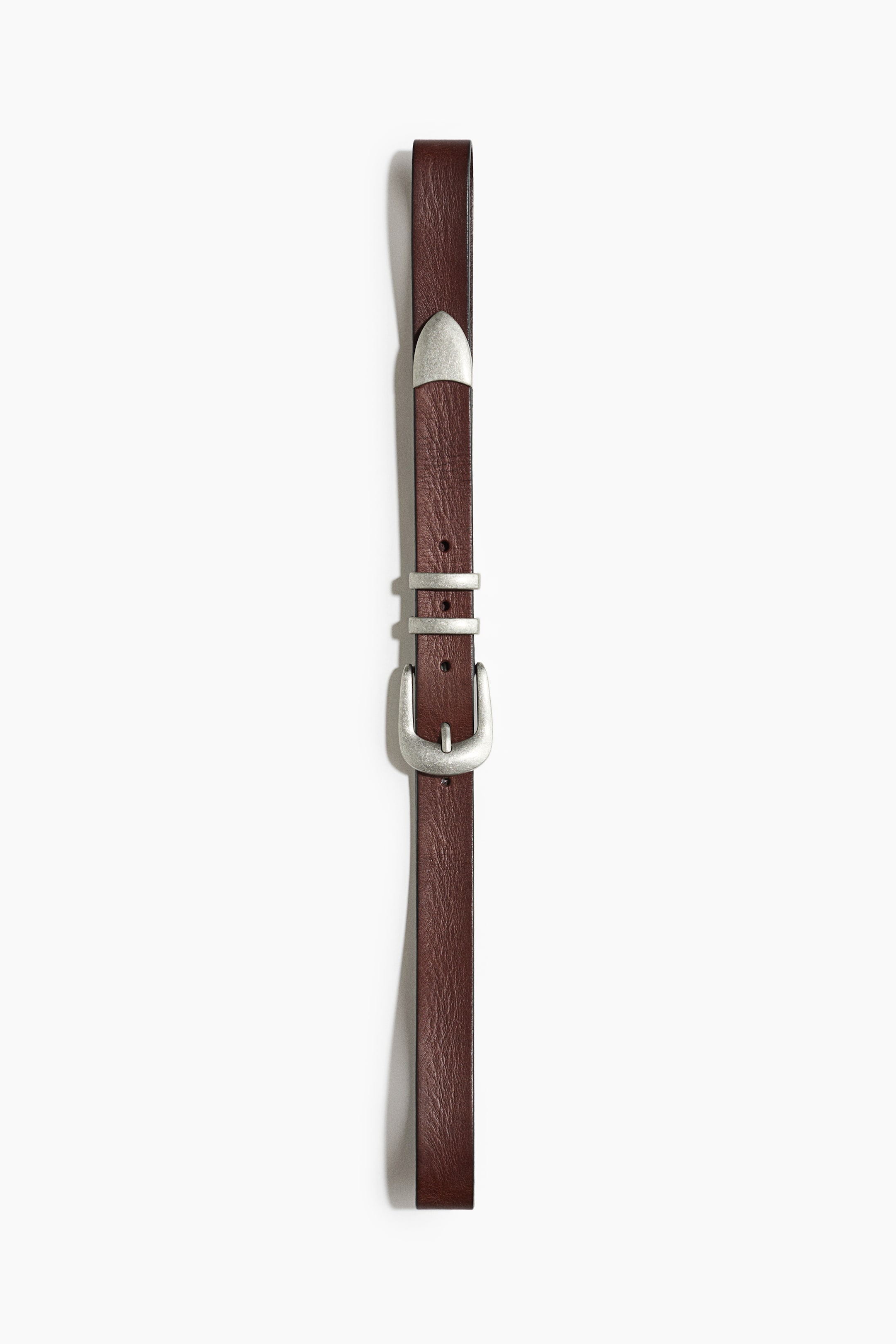 View larger image: A dark brown leather belt runs vertically, featuring a textured finish, a silver-toned horseshoe-shaped buckle, two matching metal keepers, and a pointed metal tip.