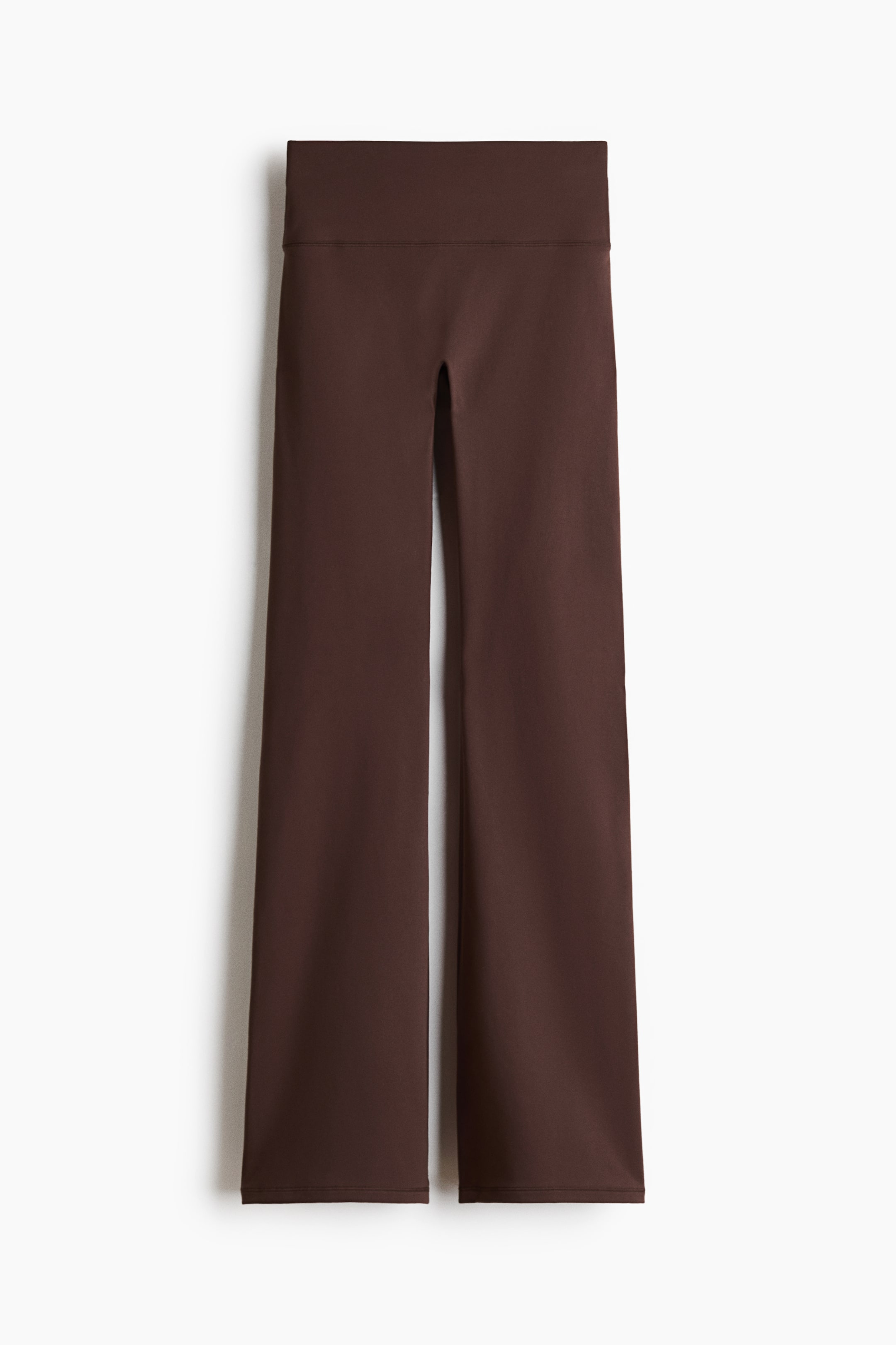 Ver imagem maior: Leggings de ioga com corte à boca de sino são exibidas de frente, apresentando uma cintura alta e larga. As pernas alargam-se em direção à bainha, e as leggings são de uma cor castanho escuro sólida.
