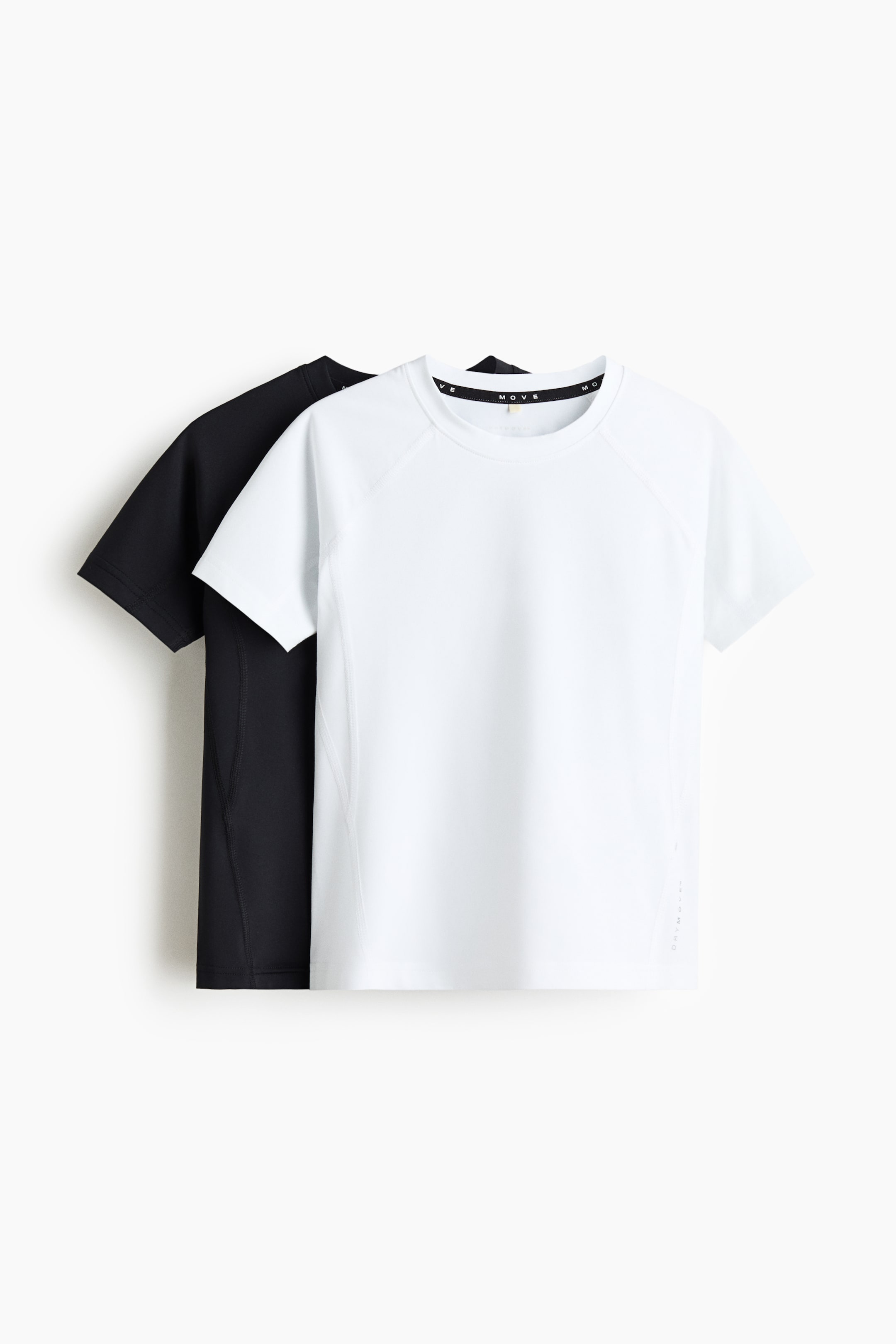 Agrandir l'image: Deux t-shirts athlétiques à manches courtes sont présentés de face, avec un t-shirt blanc chevauchant partiellement un t-shirt noir. Les deux arborent un col rond, des manches raglan et des détails de coutures latérales visibles. Le t-shirt blanc affiche également le logo 'MOVE' sur la bande intérieure du col et le texte 'DRY MOVES' verticalement sur son côté inférieur droit.