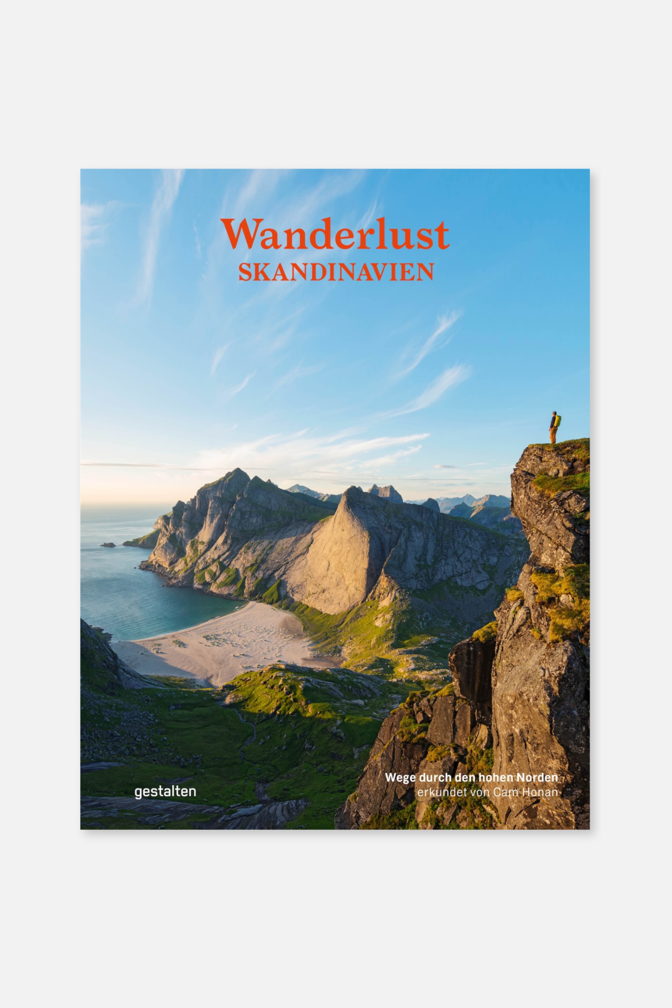Größeres Bild anzeigen: Ein Buchcover zeigt eine Landschaftsfotografie mit zerklüfteten Bergen, einem Sandstrand und einem Gewässer unter einem blauen Himmel, mit einer Person, die am Rand einer Klippe steht. Der Titel "Wanderlust SKANDINAVIEN" erscheint in roter Schrift oben, und Verlags- sowie Autoreninformationen sind unten sichtbar.