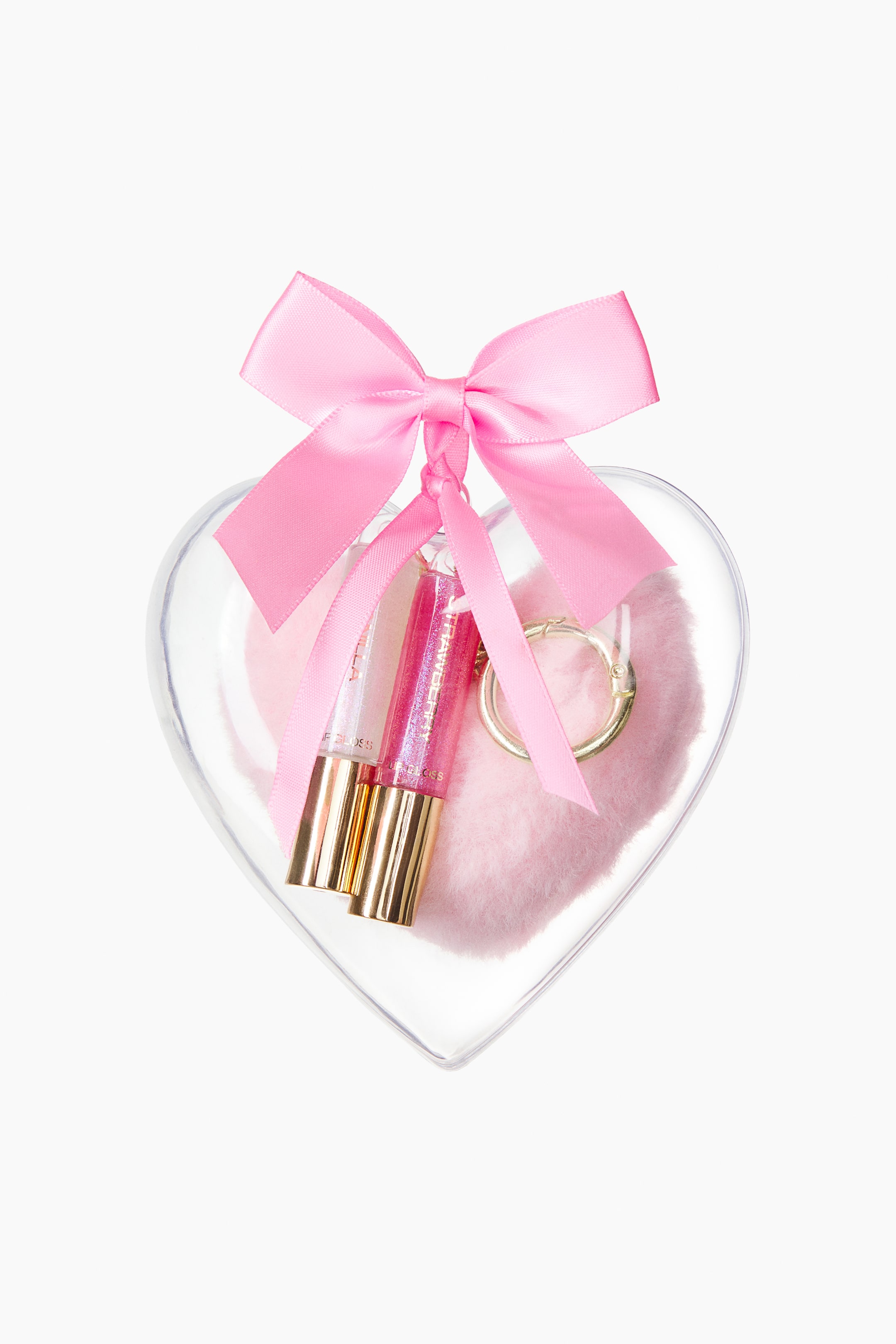 View larger image: Two shimmering lip glosses with gold-coloured caps are resting inside a clear, heart-shaped plastic bauble alongside a fluffy pink pom-pom and a gold-tone metal clasp. A pink satin ribbon is tied in a bow at the top loop of the container.
