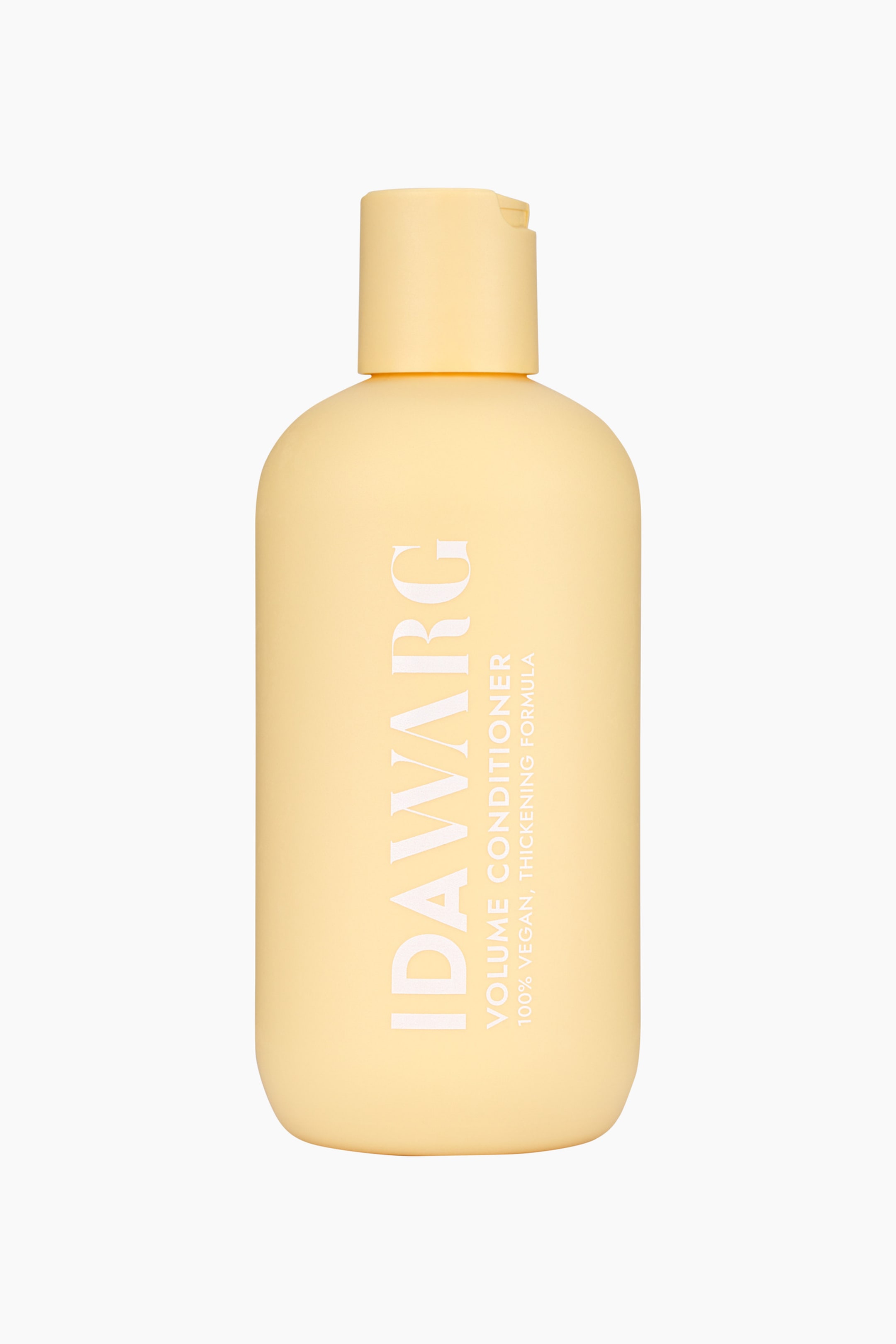 Se større billede: En lysegul IDAWVARG Volume Conditioner flaske står oprejst, let vinklet til højre, med en afrundet rektangulær krop og en matchende flip-top låg. Foran på etiketten står der "IDAWVARG Volume Conditioner" og "100% Vegansk, Fortykkende Formel" med hvid tekst.
