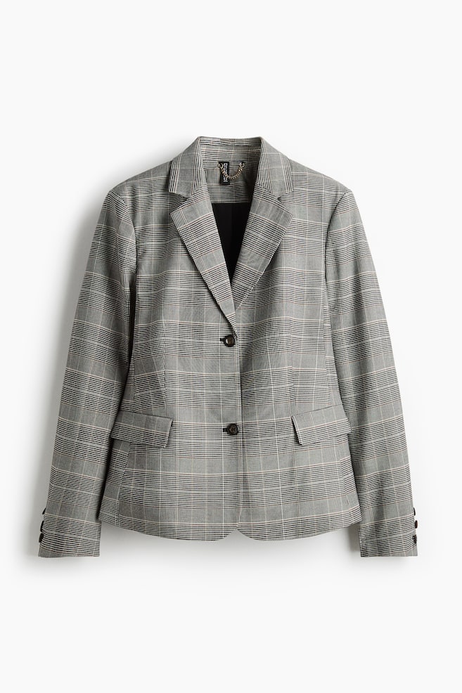 Ein einreihiger Blazer wird von vorne präsentiert und zeigt ein grau-schwarz-weiß kariertes Muster mit subtilen rötlich-braunen Linien. Er verfügt über Kerbrevers, einen einzelnen dunklen Knopfverschluss, zwei Pattentaschen an den vorderen Hüften und drei kleine dunkle Knöpfe, die jedes Bündchen zieren. - 1