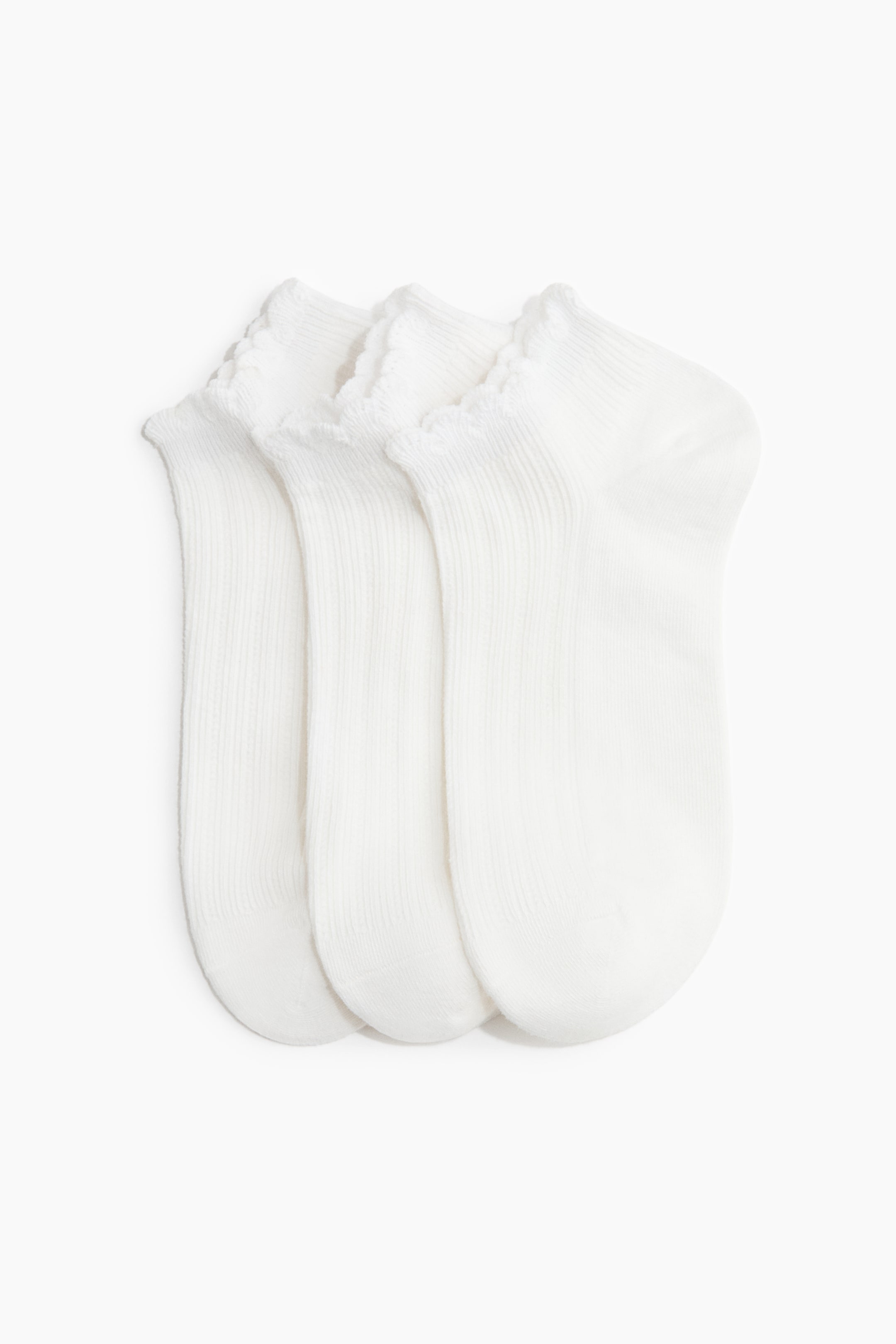 Agrandir l'image: Trois chaussettes blanches se chevauchent et sont disposées en éventail, mettant en valeur leurs poignets froncés en haut. Chaque chaussette présente une section de cheville côtelée et un pied lisse, avec le bout arrondi visible.
