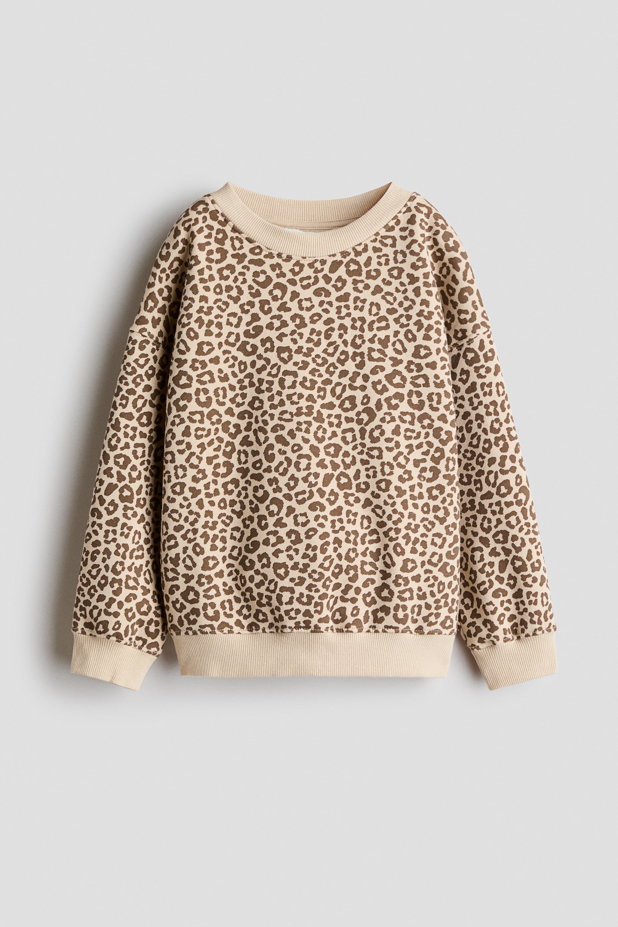 View larger image: A sweatshirt is shown with a beige and brown leopard print, featuring a front view with a crew neckline trimmed in ribbing, dropped shoulders, long sleeves, and ribbed cuffs and hem.