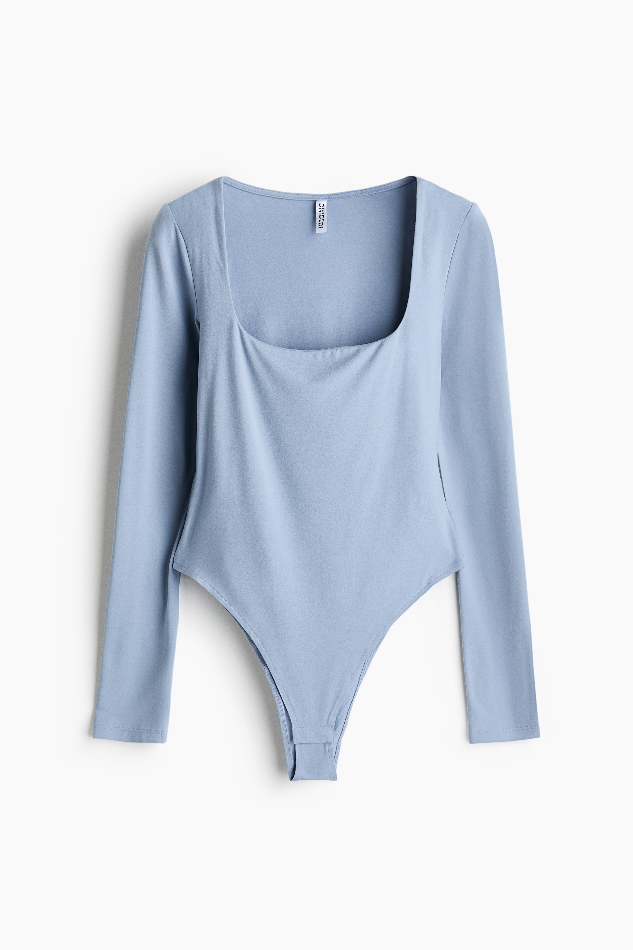 View larger image: A light blue bodysuit is shown from the front, featuring long sleeves, a deep square neckline, and high-cut sides with a snap-button closure at the crotch.