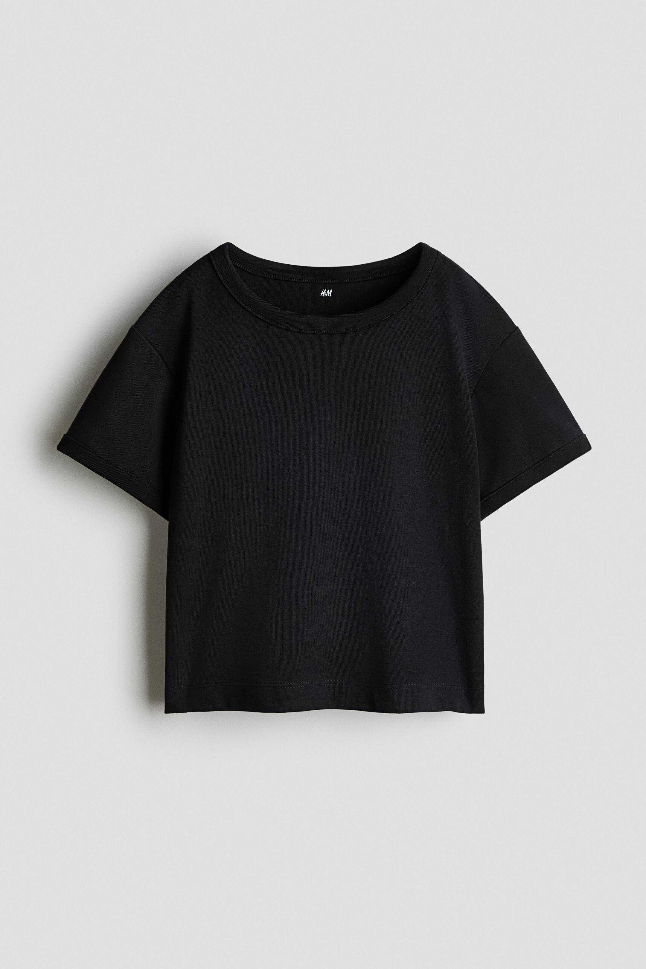 View larger image: A black cropped T-shirt is shown from the front, featuring a wide crew neck, dropped shoulders, and short, wide sleeves. The shirt presents a relaxed, boxy silhouette with a straight-cut, stitched hem.