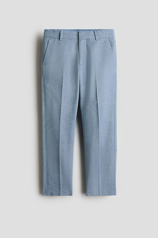Pantalon bleu clair en mélange présenté de face, doté d'une taille plate avec passants pour ceinture, de poches latérales inclinées et de plis marqués sur le devant. - 1