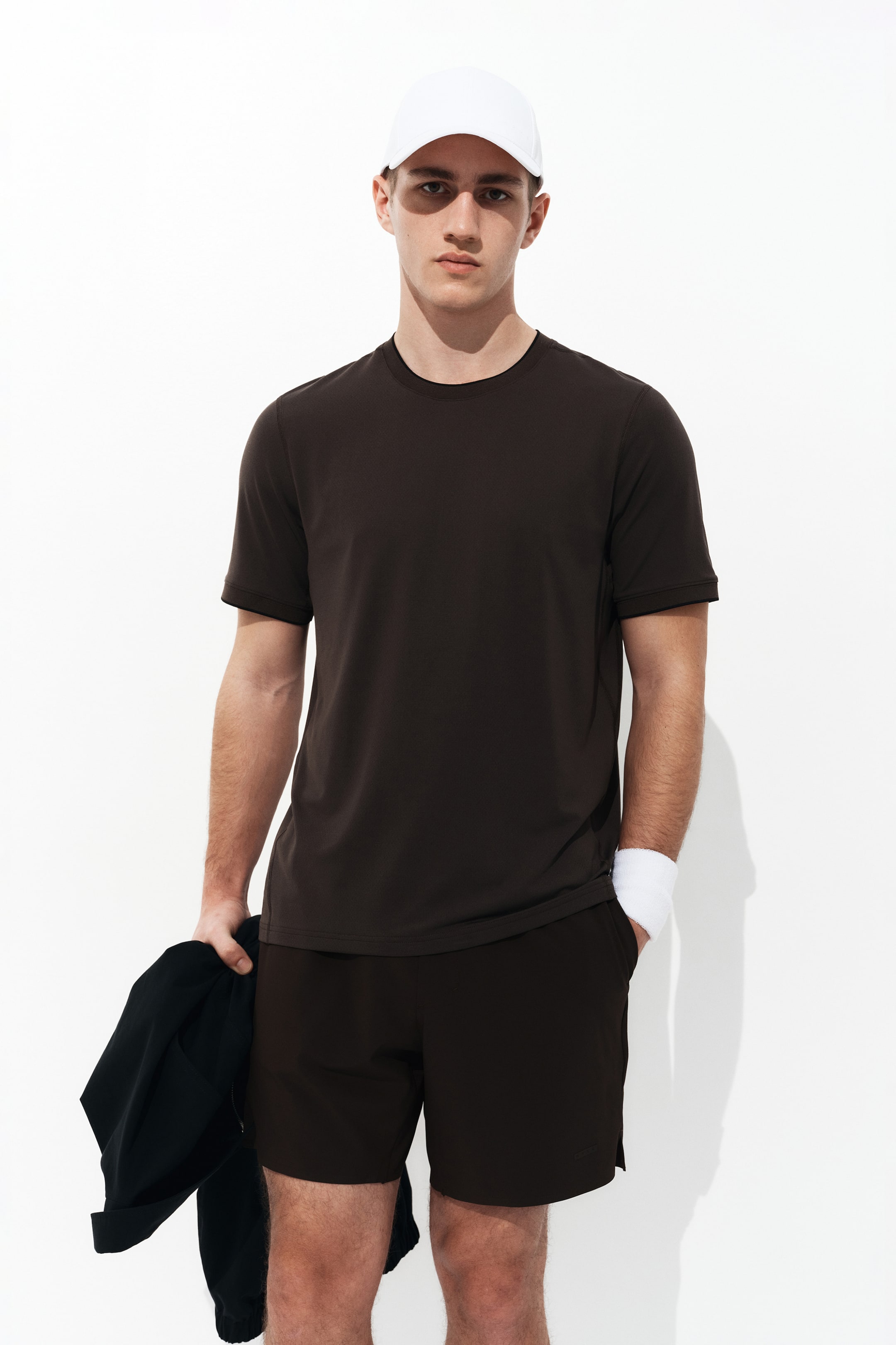 View larger image: A dark brown short-sleeved t-shirt is being worn by a person facing forward, featuring a smooth fabric, a crew neck, and a straight hem.
