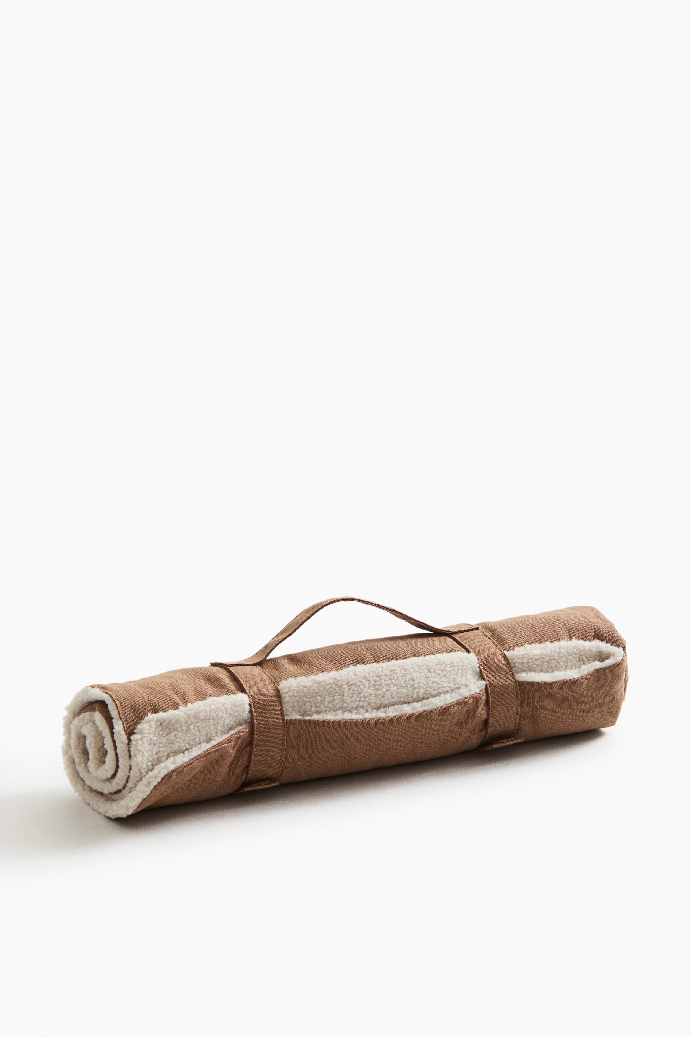 A pet blanket featuring a brown cotton canvas exterior and a soft, white teddy fleece lining is draped over a dog's head, with only its nose and snout peeking out from underneath.
