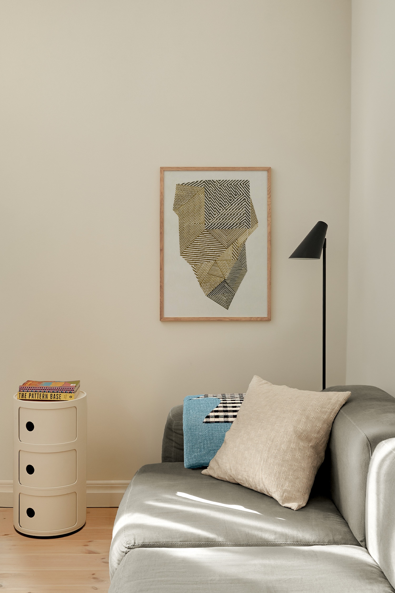 Una stampa artistica mette in risalto un design geometrico sfaccettato composto da sezioni intersecanti con sottili strisce parallele nelle tonalitÃ  del giallo senape, del verde oliva e del marrone scuro. I motivi a righe creano un aspetto tridimensionale, cristallino su uno sfondo texturizzato bianco sporco.