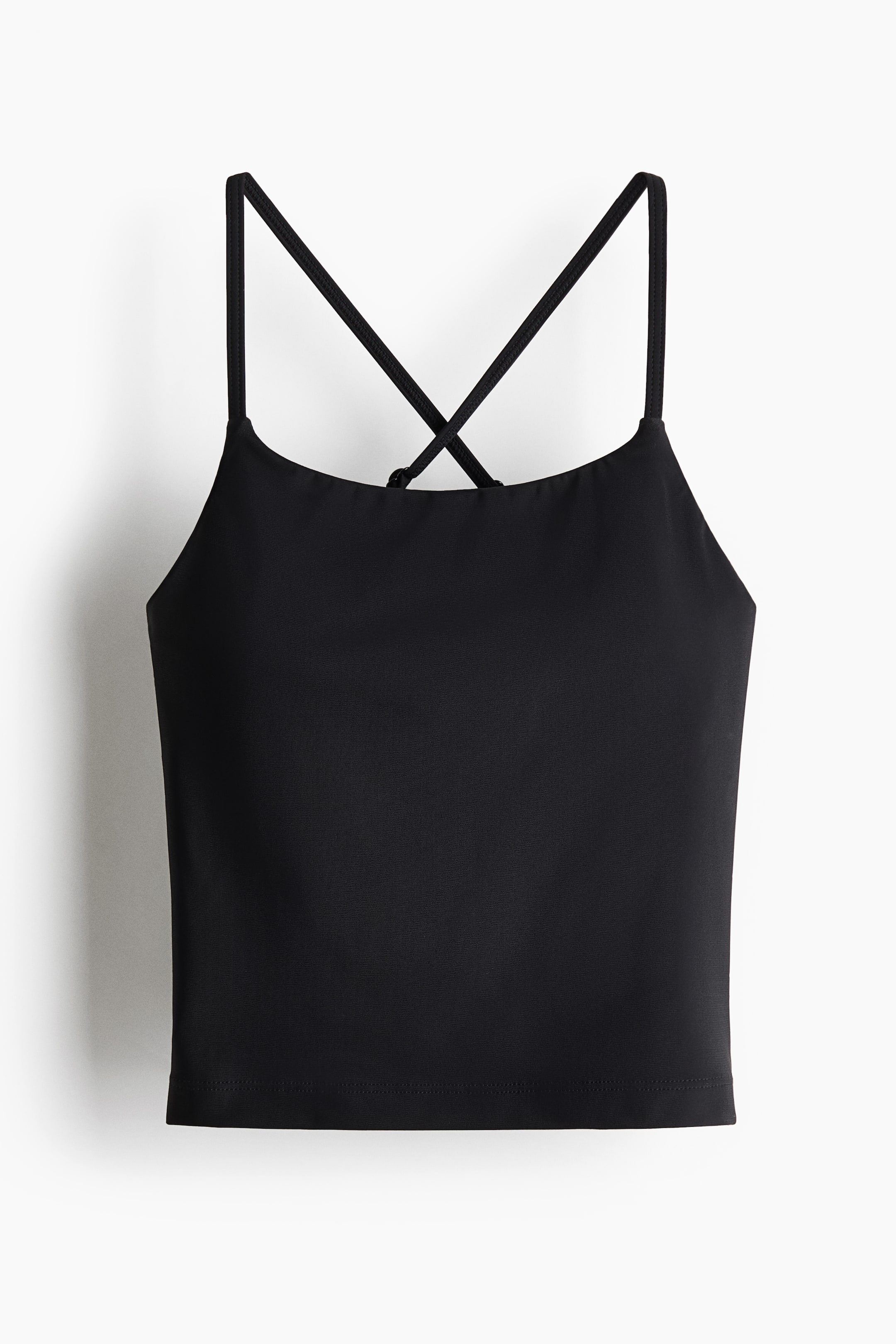 Grösseres Bild ansehen: Ein schwarzes, kurzes Tanktop zeigt seine Vorderansicht. Es verfügt über einen geraden Ausschnitt und dünne Spaghettiträger, die sich am Rücken kreuzen.
