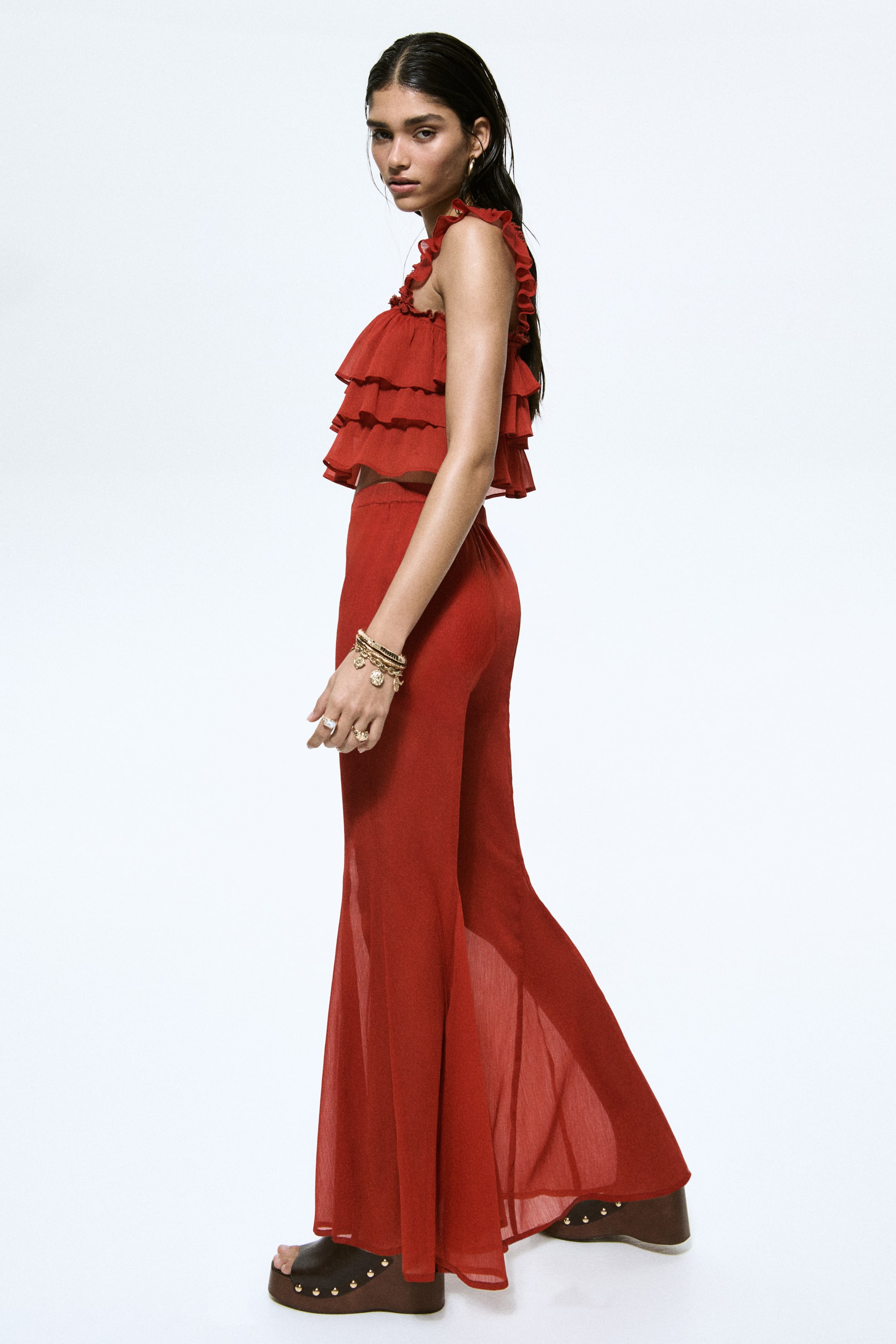 View larger image: Trousers in a deep red, sheer, crinkled weave are being worn by the model. 