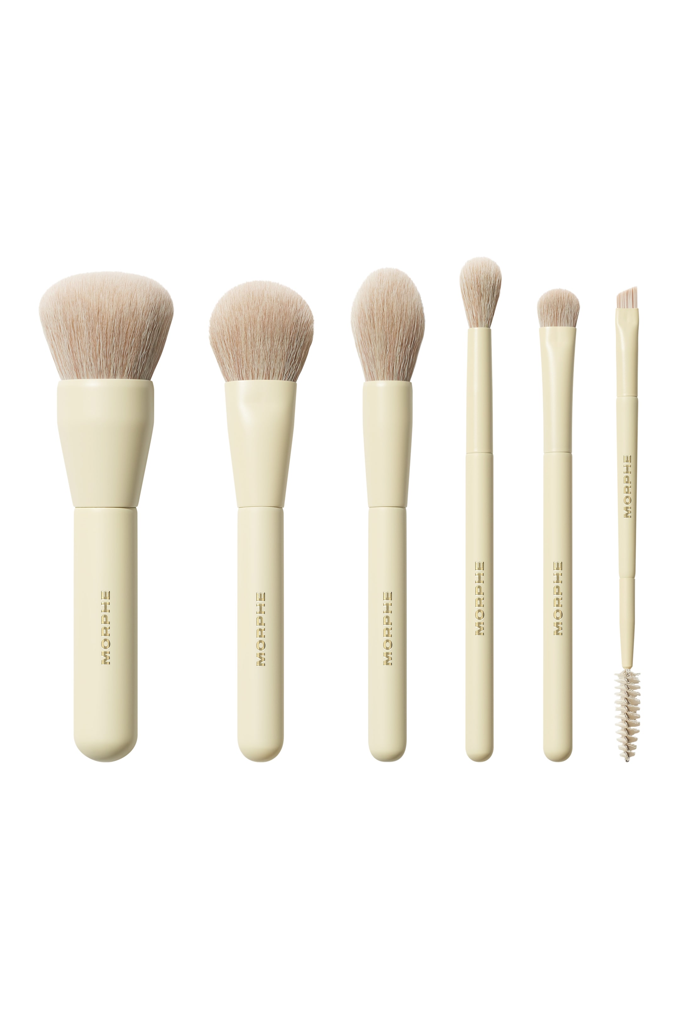 Visa större bild: Ett set med sex Morphe-sminkborstar är arrangerade i rad, med blekgula handtag med "MORPHE"-logotyp och ljusbeige borst. Borstarna visar upp en mängd olika former och storlekar, inklusive fluffiga puder- och blandningsborstar, en platt vinklad borste och en dubbeländad borste med en spoolie.