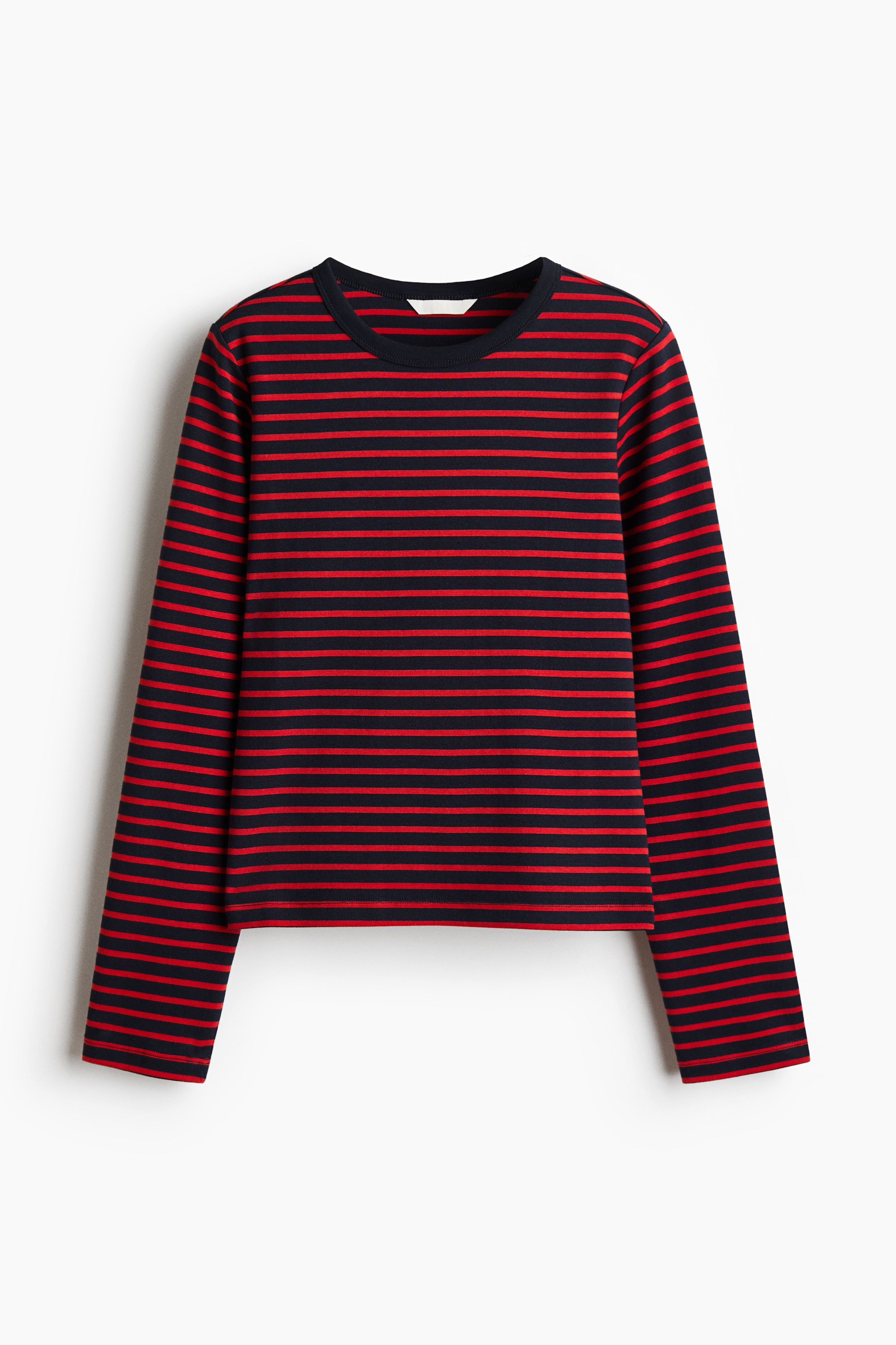 The model is wearing a heavy jersey top with horizontal red and navy blue stripes, a round rib-trimmed neckline, and long sleeves. The top is paired with white trousers.