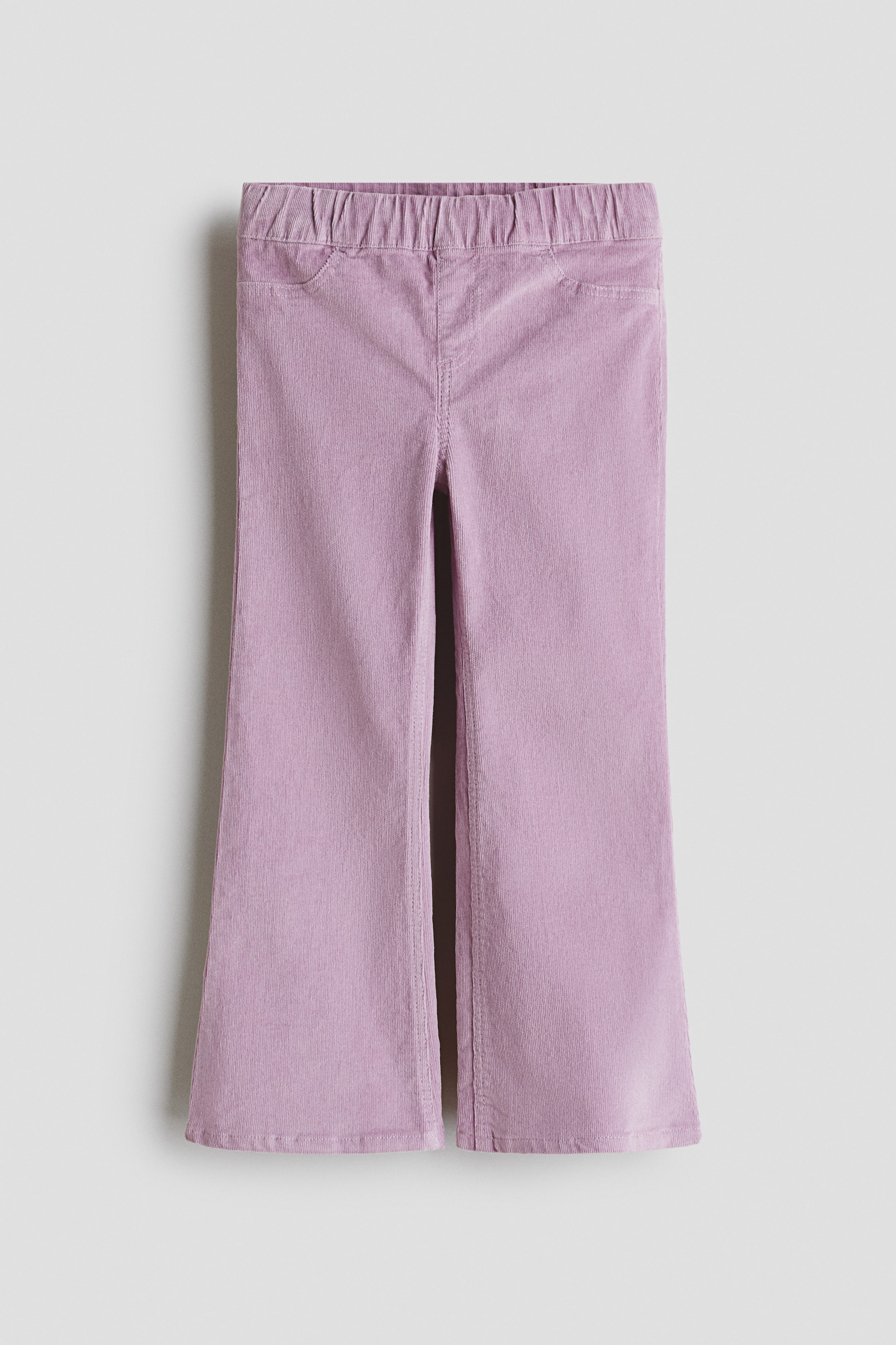 Grotere afbeelding bekijken: Een paar lila corduroy treggings wordt aan de voorkant weergegeven, met een elastische tailleband, gestikte details voor een nep gulp en nep voorzakken, en pijpen die uitlopen aan de zoom.