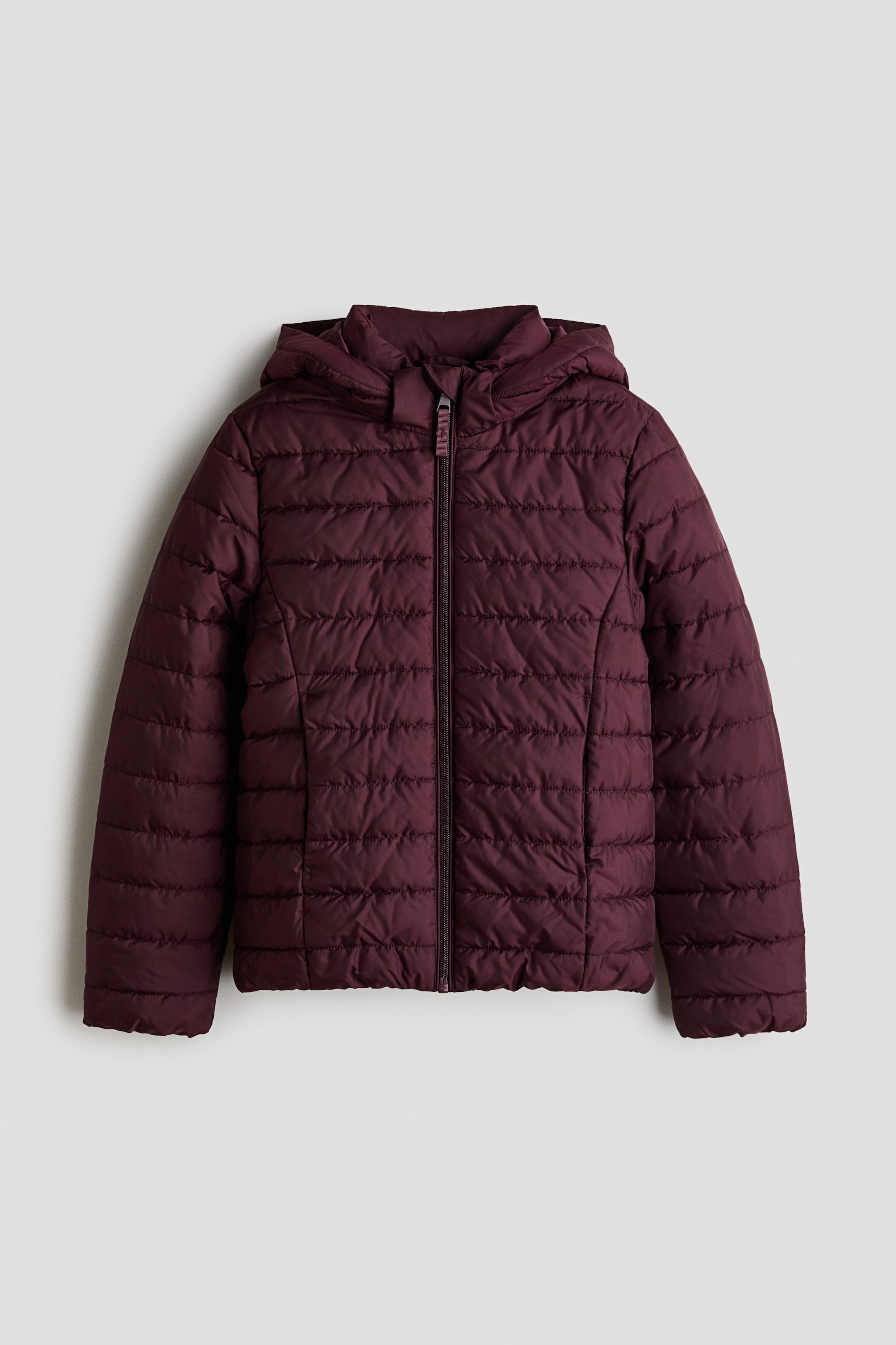 View larger image: A maroon puffer jacket is shown facing forward, featuring horizontal quilting and an attached hood. It is designed with a full-length zipper closure down the front and discreet side pockets.
