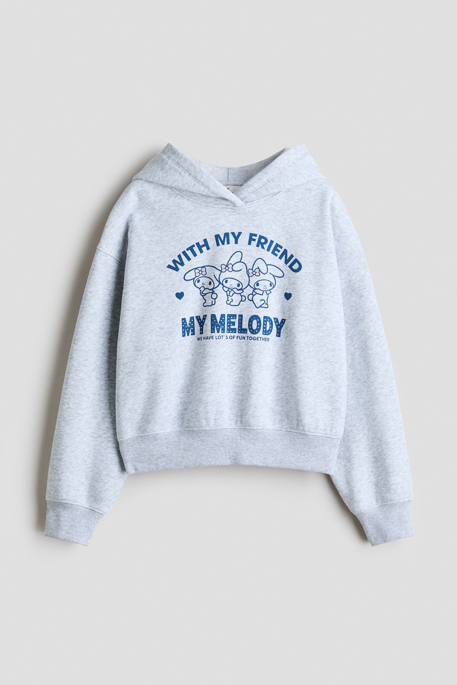 A light grey mÃ©lange hoodie is shown from the front, featuring a wrap-front hood, dropped shoulders, and ribbed cuffs and hem. The chest displays a blue graphic print of cartoon characters with the text "WITH MY FRIEND MY MELODY."