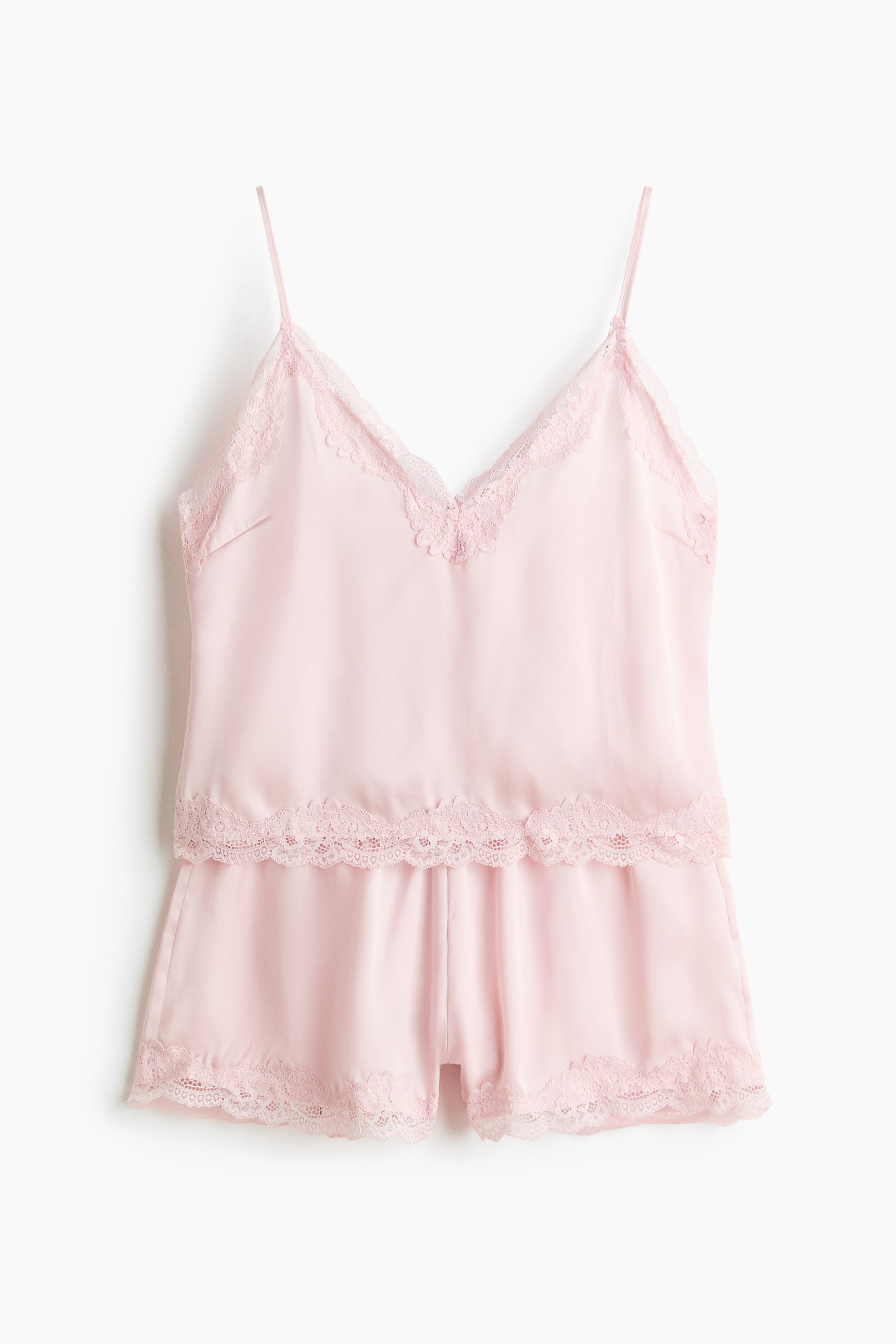 View larger image: Pink pajamas, featuring a strappy top and shorts, are shown from the front. The softly draping satin top includes spaghetti shoulder straps and a V-shaped neckline, with lace trims accentuating both the neckline and the hem. The shorts feature a covered elastic waistband and lace trims along the leg openings.