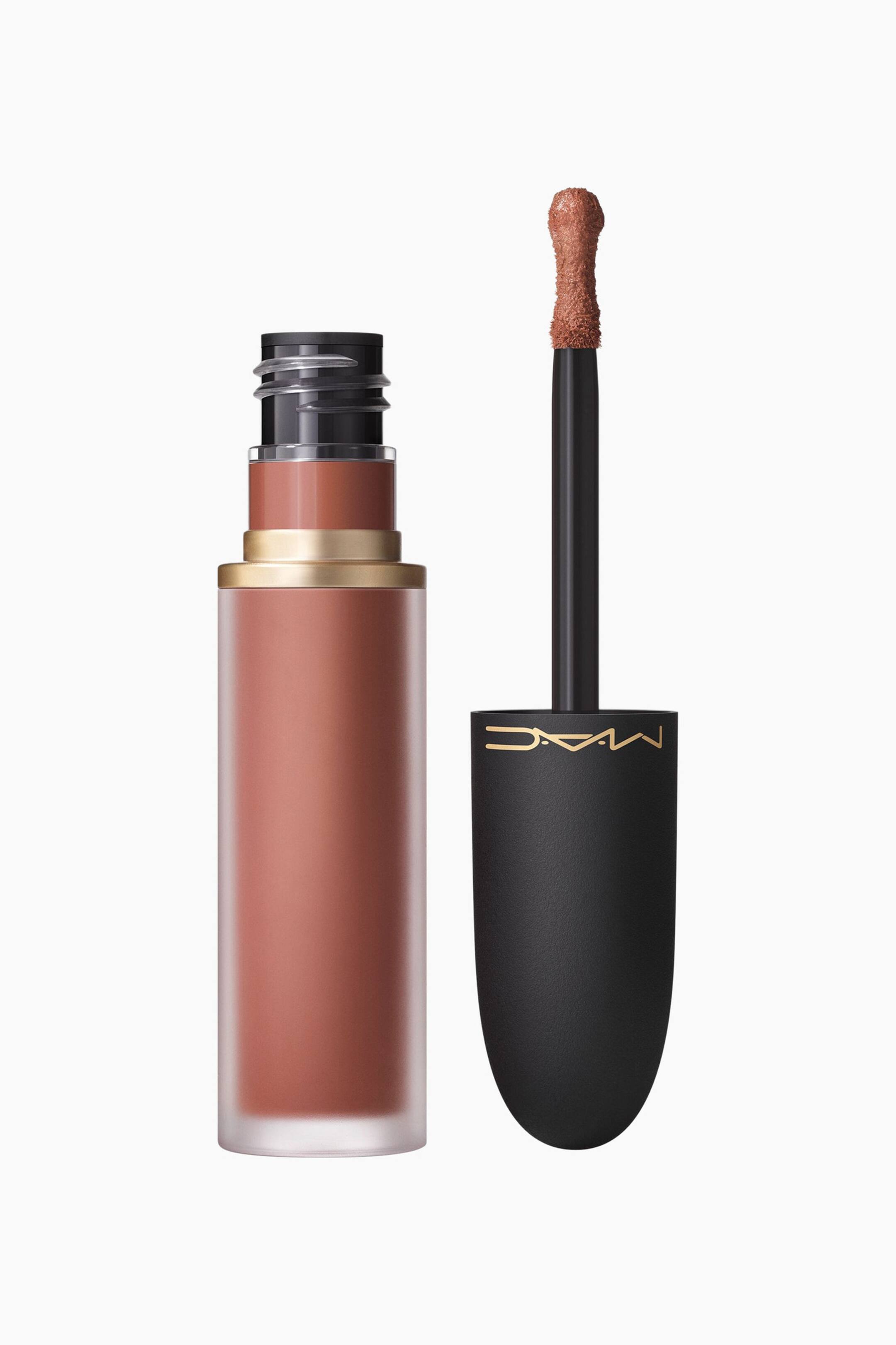 Visa större bild: En varm brun flytande läppstift visas i ett frostat rör med en separat applikator, sett från en rak, något förhöjd vinkel. Applikatorn visar en flockad hjortfot spets mättad med läppstiftet, och dess svarta lock visar en guldfärgad "MAC"-logotyp.