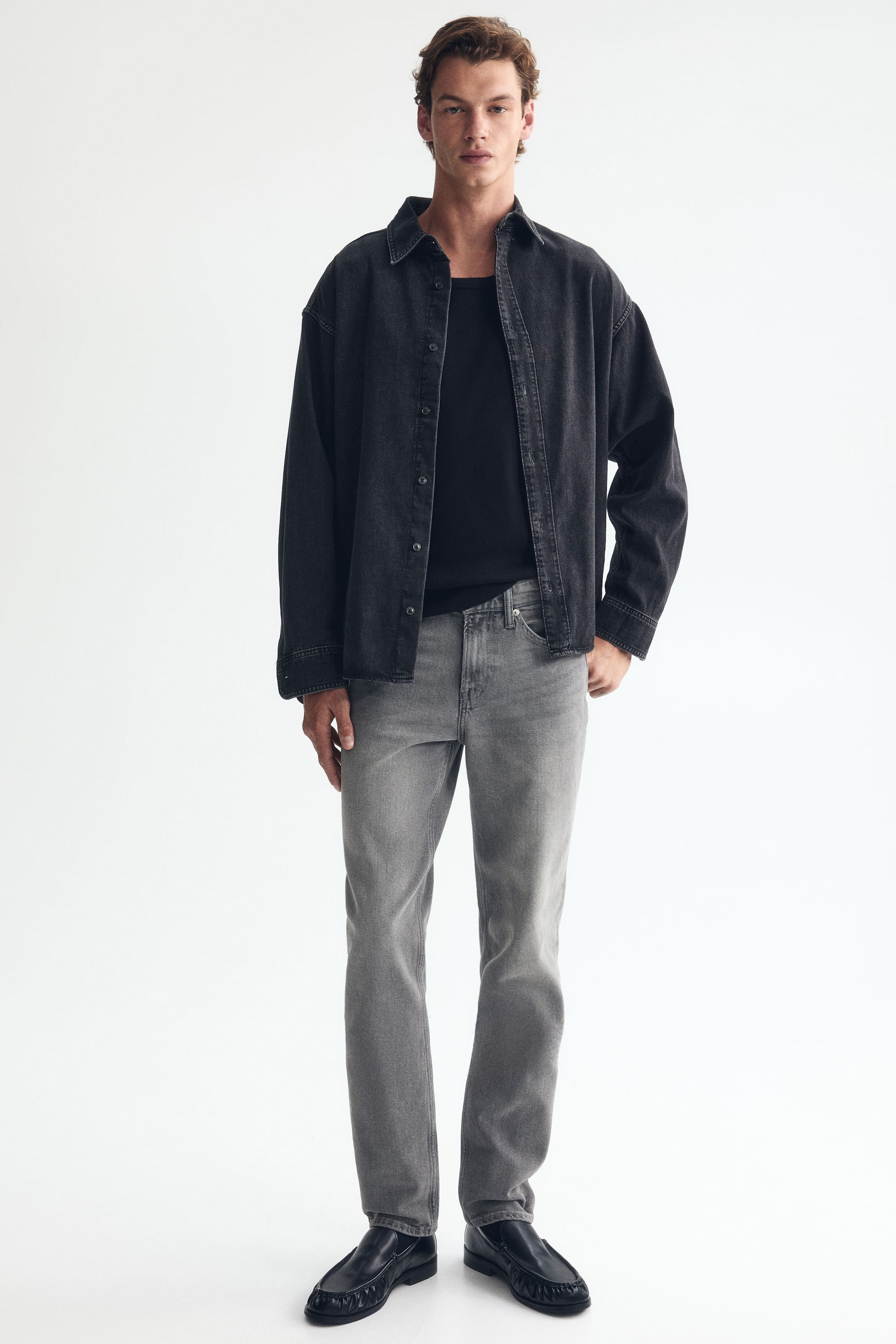 Visa större bild: Gråa 5-ficks jeans i denim med normal midja, raka ben och smal passform bärs av modellen. Modellen står med ena handen vilande i en framficka.