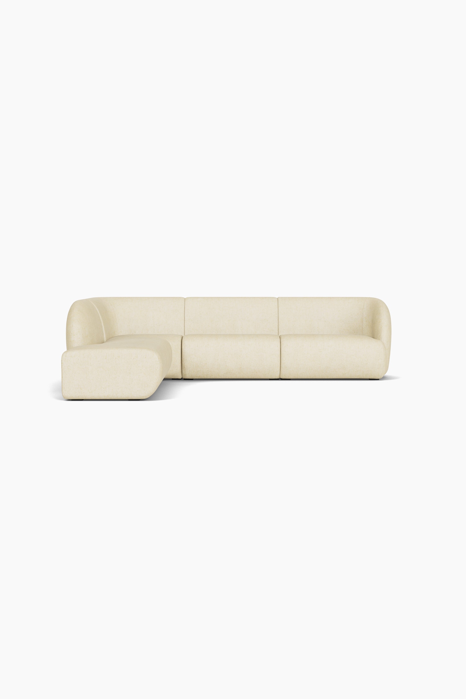 Un canapé sectionnel modulable en tissu bouclé texturé de couleur crème est présenté dans une configuration en L à profil bas, avec des bords arrondis. Le canapé est doté dâassises profondes et moelleuses et est mis en scène avec trois coussins décoratifs carrés assortis.