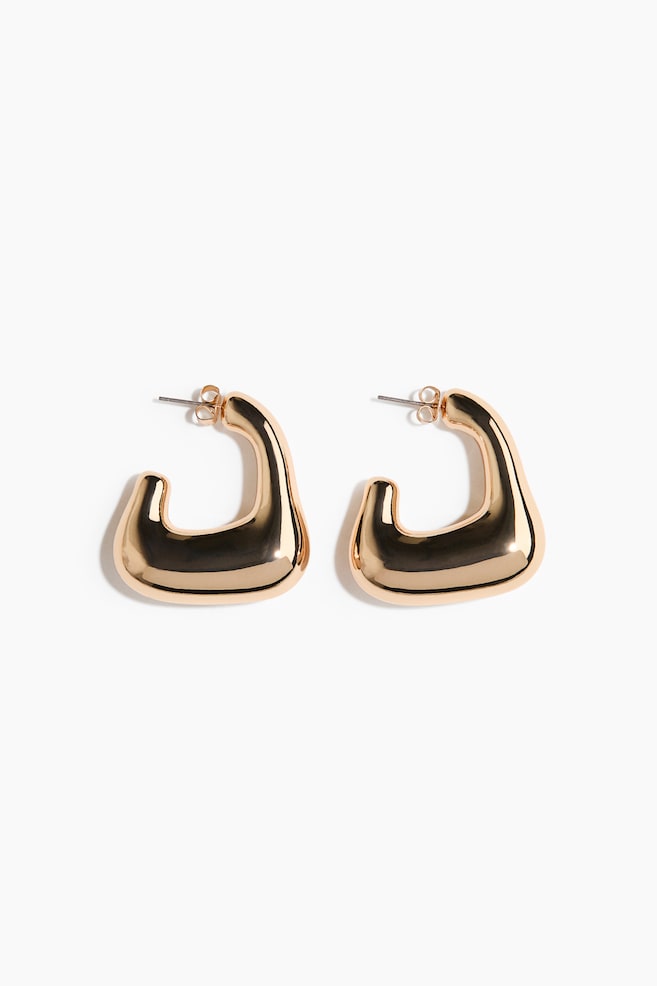 A pair of gold-toned earrings showcasing a chunky, irregular, open square shape with heavily rounded corners and a central top indentation, featuring a polished finish and visible post-back closures. - 1