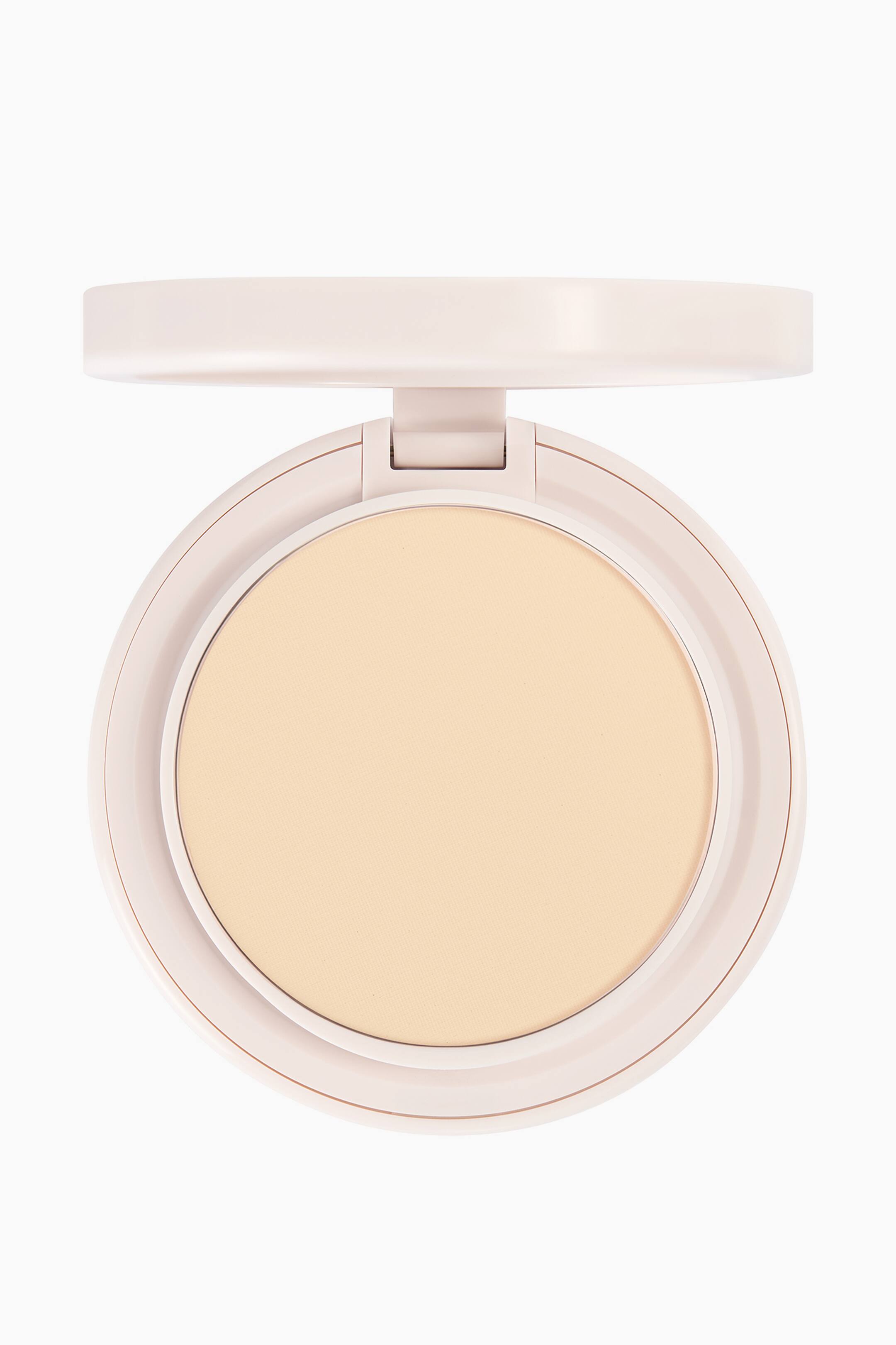 Visa större bild: Natural Blur Powder Foundation presenteras i ett öppet, runt, ljusrosa puderfack sett rakt framifrån. Facket visar ett slätt, ljusbeige pressat puder med matt finish, medan locket vilar öppet upptill.