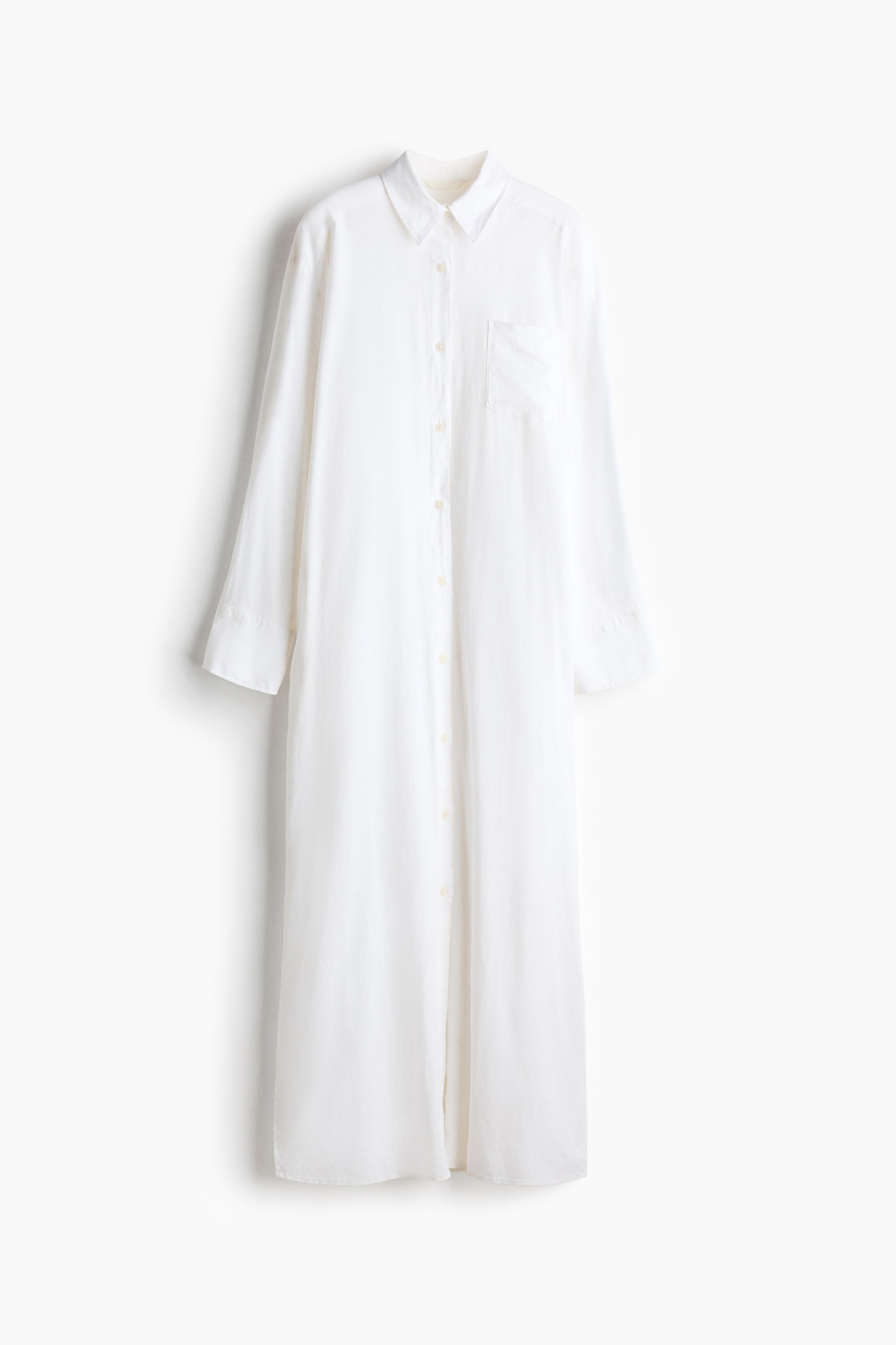 查看大圖: 白色長裙正面展示，設計有領口，前襟排扣，長袖配有扣式袖口，左側有一個開放式胸袋。