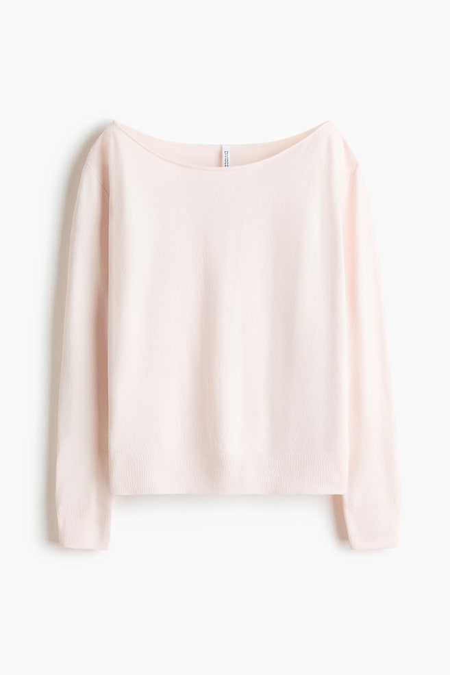 A light pink, fine-knit sweater is shown from the front, featuring a wide boat neckline and long sleeves with ribbed cuffs. The garment is displaying a matching ribbed hem and a soft, smooth knit texture. - 1