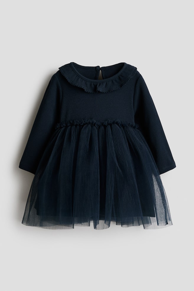 A navy blue long-sleeve dress is shown from the front, featuring a ribbed bodice with a frill-trimmed round neckline and a matching frilled waist. The dress is finished with a flared, layered tulle skirt. - 1