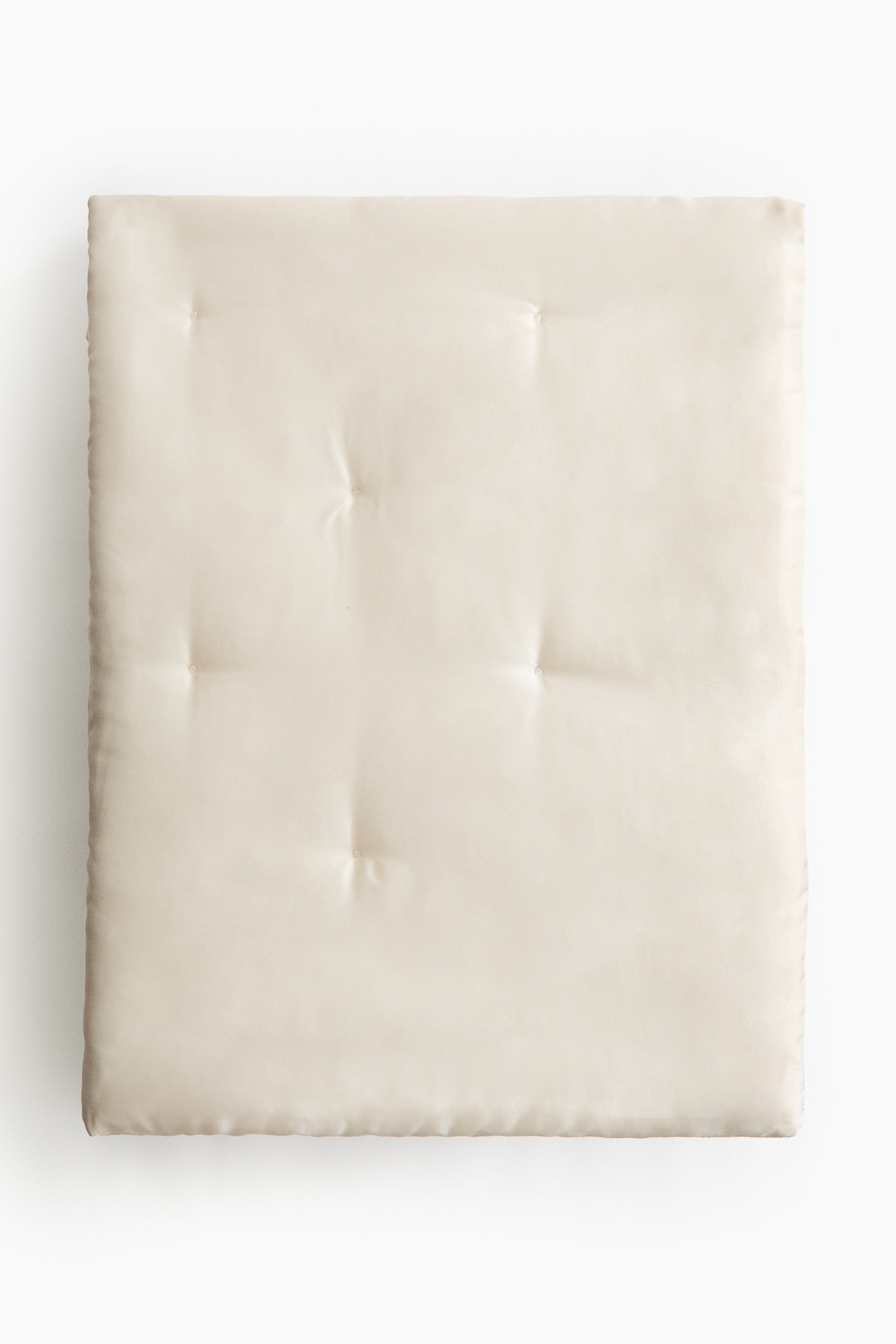 View larger image: A square, cream-colored padded mat is presented at the front, featuring a smooth surface with a subtle sheen and nine tufted indentations arranged in a 3x3 grid.