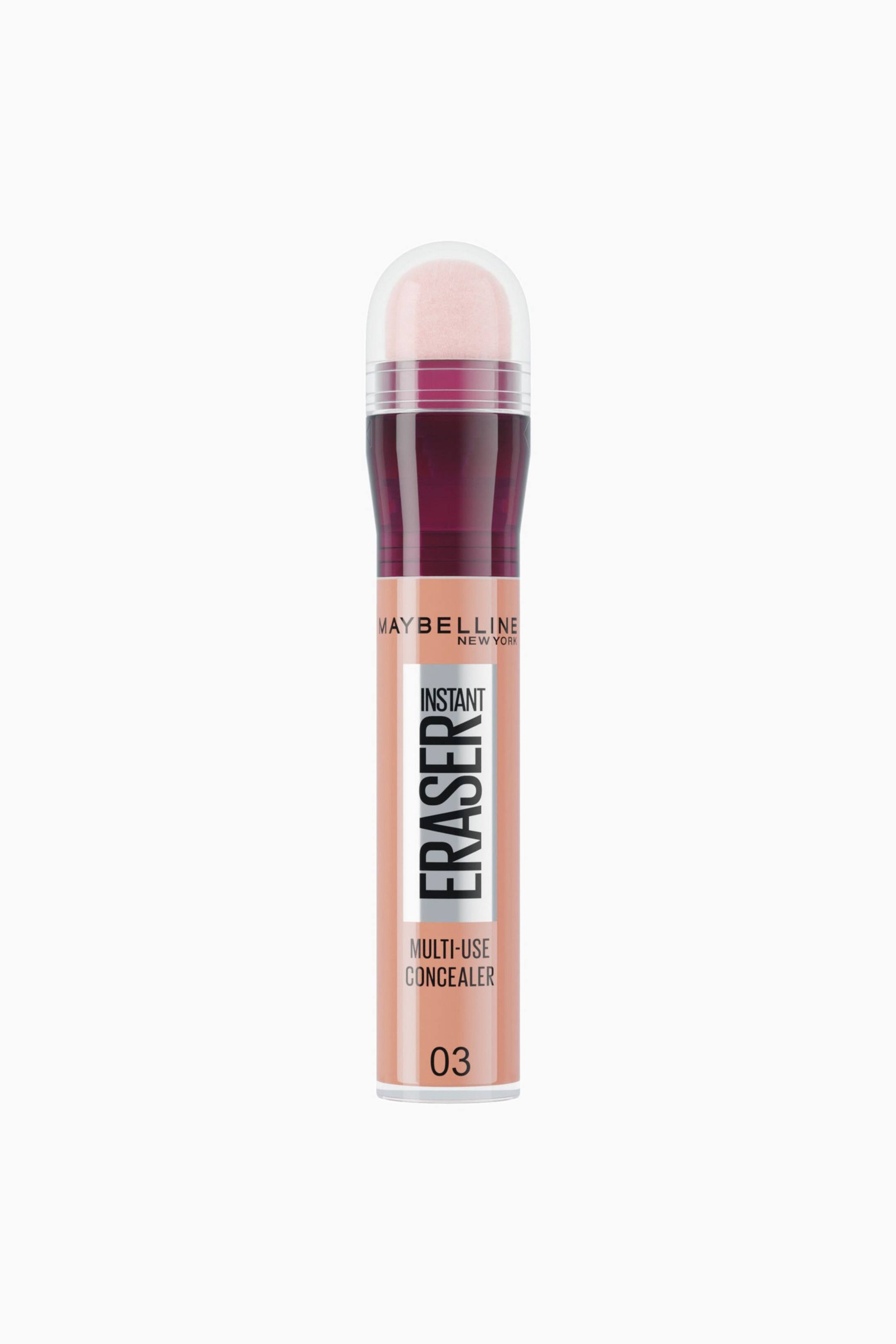 Se større billede: En Maybelline Instant Eraser Multi-Use Concealer-tube i nuance 03 står lodret og vender fremad og viser en cylindrisk beholder fyldt med lys beige væske. Beholderen har en mørkerød krave og en afrundet svampeapplikator indkapslet i en gennemsigtig plastikhætte.