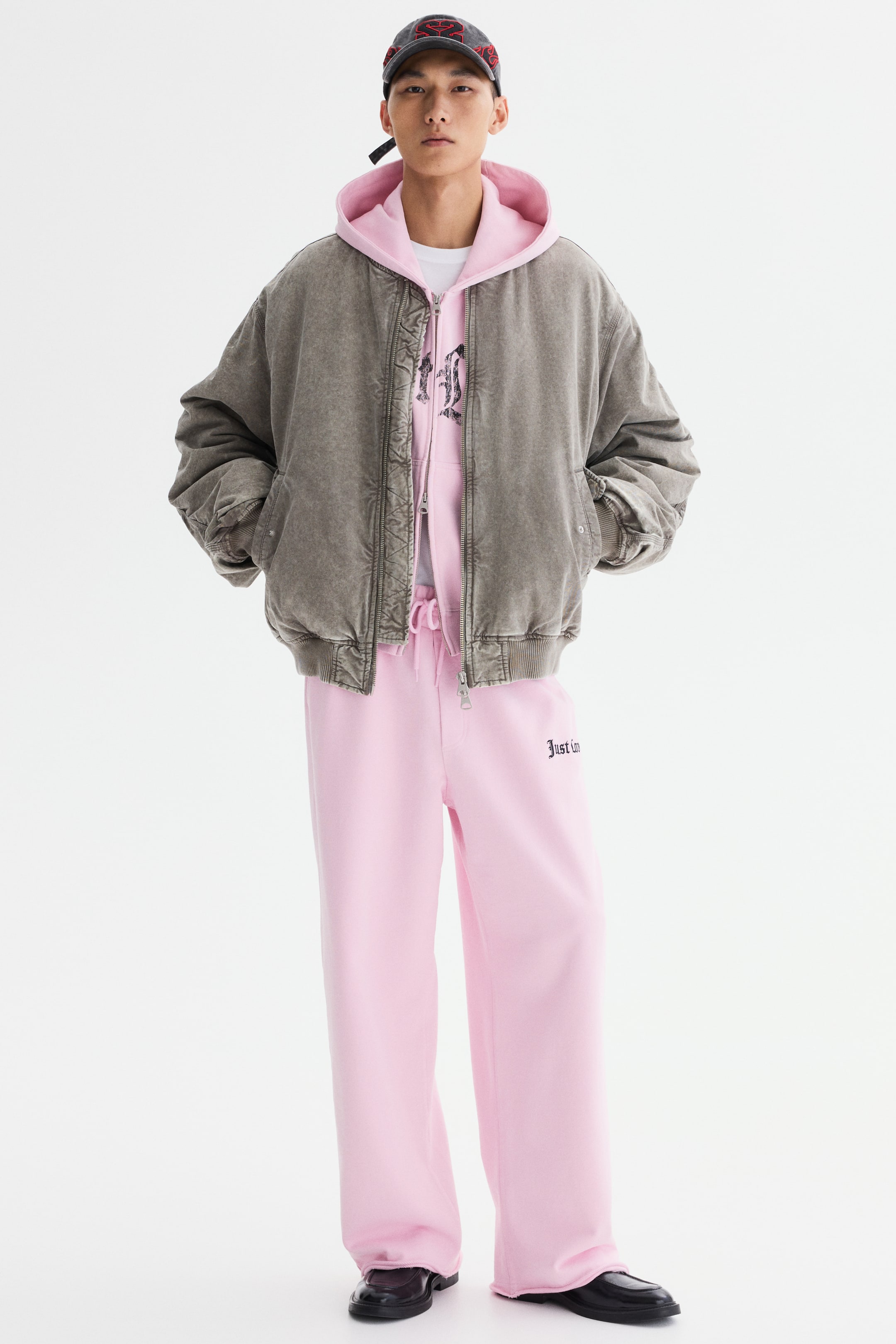 Ampliar la imagen: Una chamarra bomber gris lavada presenta un ajuste oversized y relajado con mangas voluminosas; está diseñada con cierre frontal de cremallera completo, puños y dobladillo acanalados, y detalles acolchados a lo largo de la tapeta. La chamarra se muestra abierta, de frente.