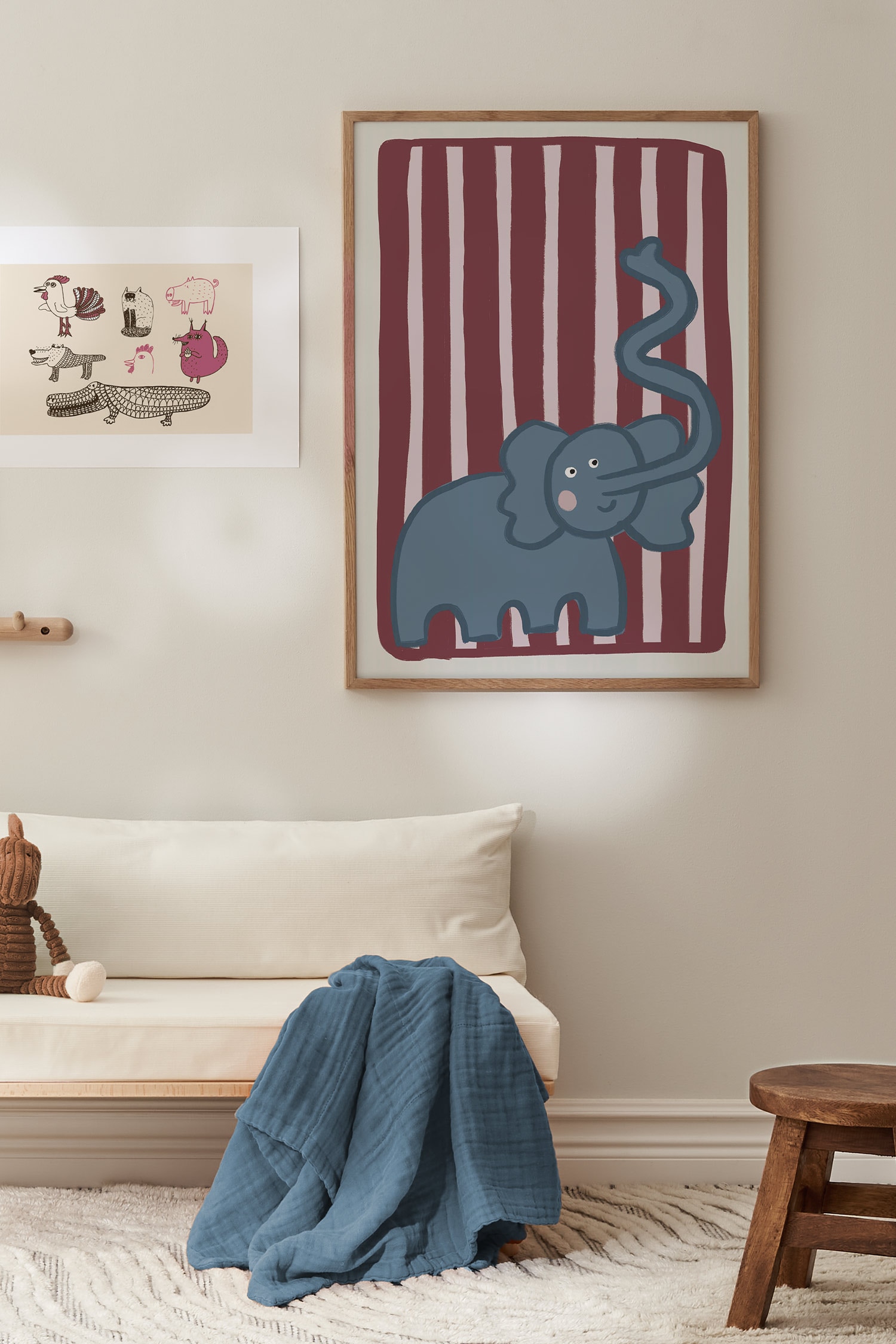 Een kunstprint toont een gestileerde blauwe olifant met een lange, golvende slurf die omhoog krult, geplaatst tegen een achtergrond van afwisselende donkerrode en lichtroze verticale strepen. De illustratie wordt gepresenteerd op een verticale rechthoekige kaart met een lichtbeige rand.