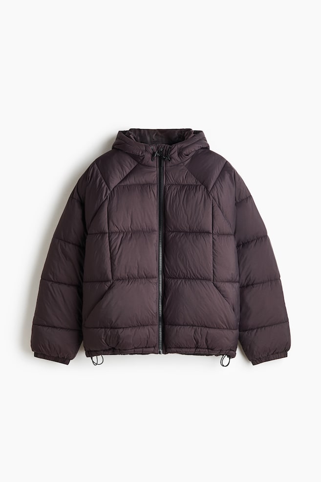 A dark brown hooded puffer jacket is facing front, featuring a block-quilted design, a full-length front zipper, and an attached hood with drawstrings. The jacket is displaying raglan sleeves with elastic cuffs and an adjustable drawstring hem. - 1