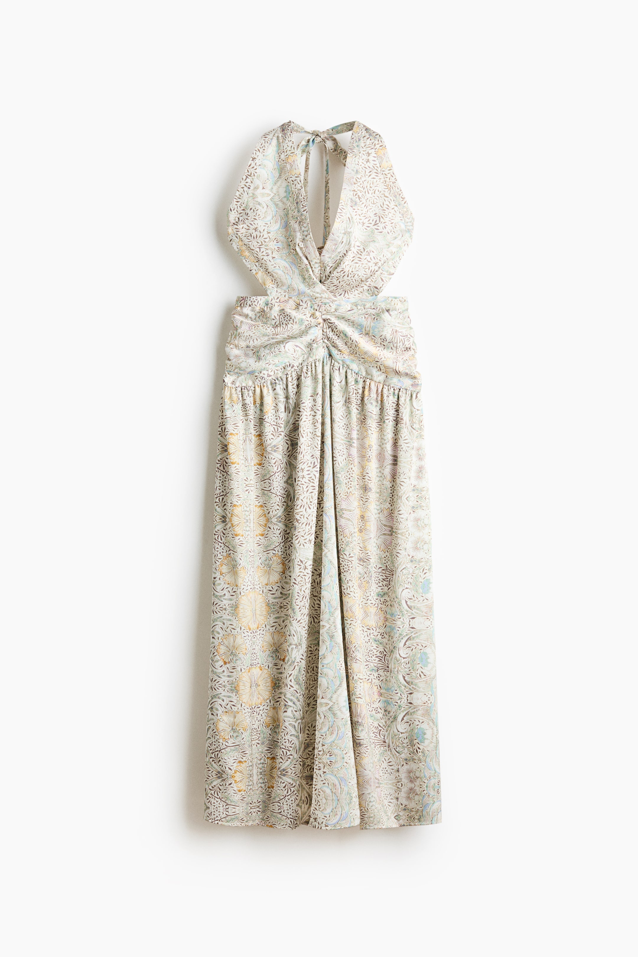 View larger image: A long halter-neck dress features a deep V-neckline, open side cutouts, and halter ties at the back of the neck, as shown from the front. It has a gathered waist panel and a flared skirt, all adorned with an intricate, multicolored floral pattern.