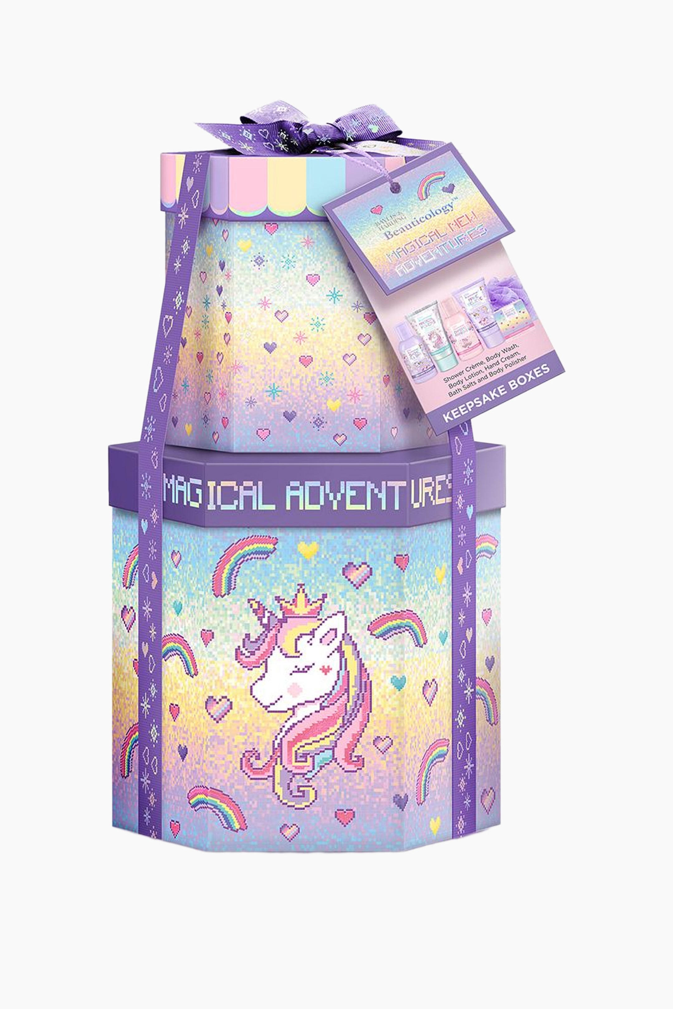 Visa större bild: Pamper Present Gift Set innehåller två staplade minnesboxar med flera sidor, dekorerade med pastellfärgade regnbågsgradienter och pixelerad grafik. Den större boxen längst ner visar en central illustration av en enhörning med krona, medan ett lila mönstrat band är virat vertikalt runt båda boxarna och knutet till en rosett upptill. En stor rektangulär presentetikett hänger från rosetten och visar de bath- och body care-produkter som ingår i setet.