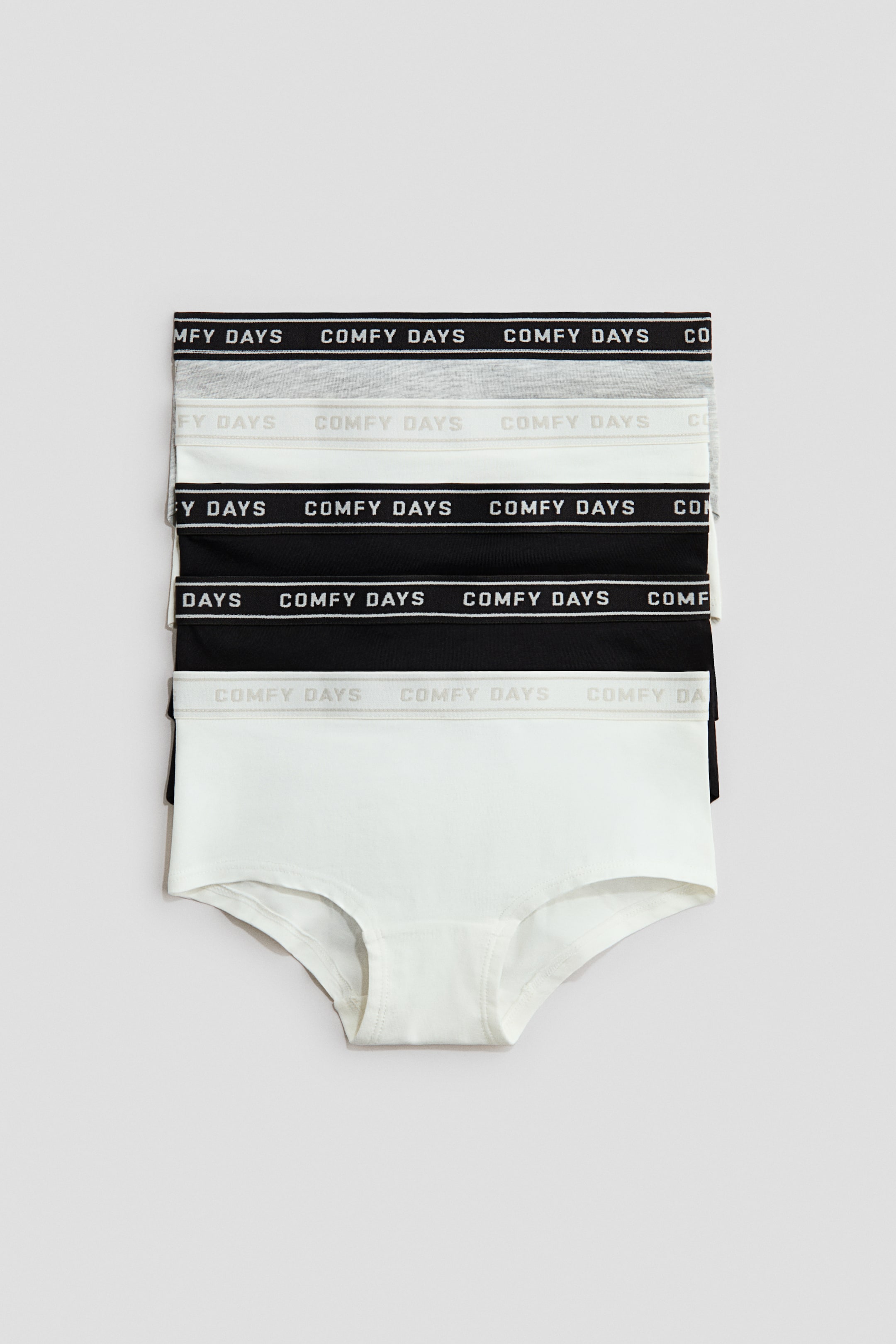 View larger image: A stack of six women's briefs is presenting FRONT, showing two white, two light gray, and two black pairs. Each pair is featuring an elastic waistband that is displaying "COMFY DAYS" text.