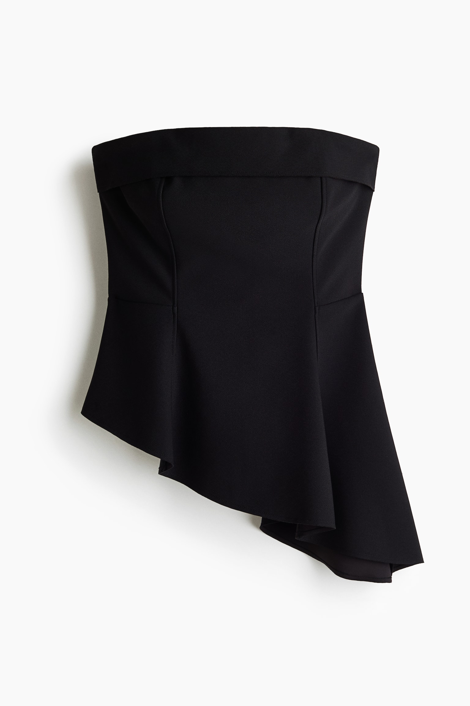 A black strapless top, front-facing, showcases a structured bodice with vertical seams and a folded-over band along the straight neckline. The top flares into an asymmetrical peplum hemline, draping lower on the right-hand side.