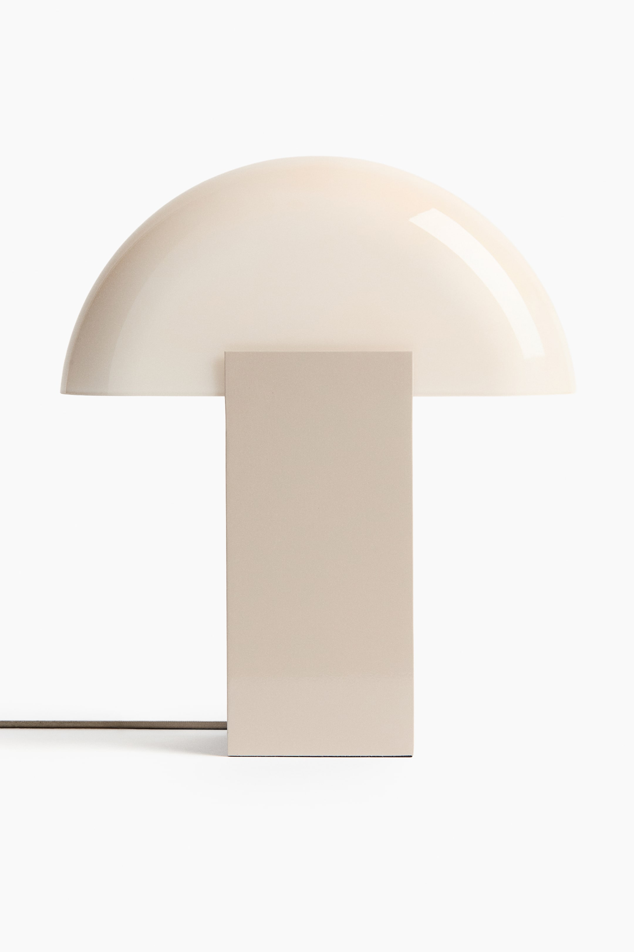 Größeres Bild ansehen: Eine moderne Tischlampe mit einem transluzenten, cremeweißen, halbkreisförmigen Kuppelschirm, der auf einem soliden, hellbeigen rechteckigen Sockel ruht.