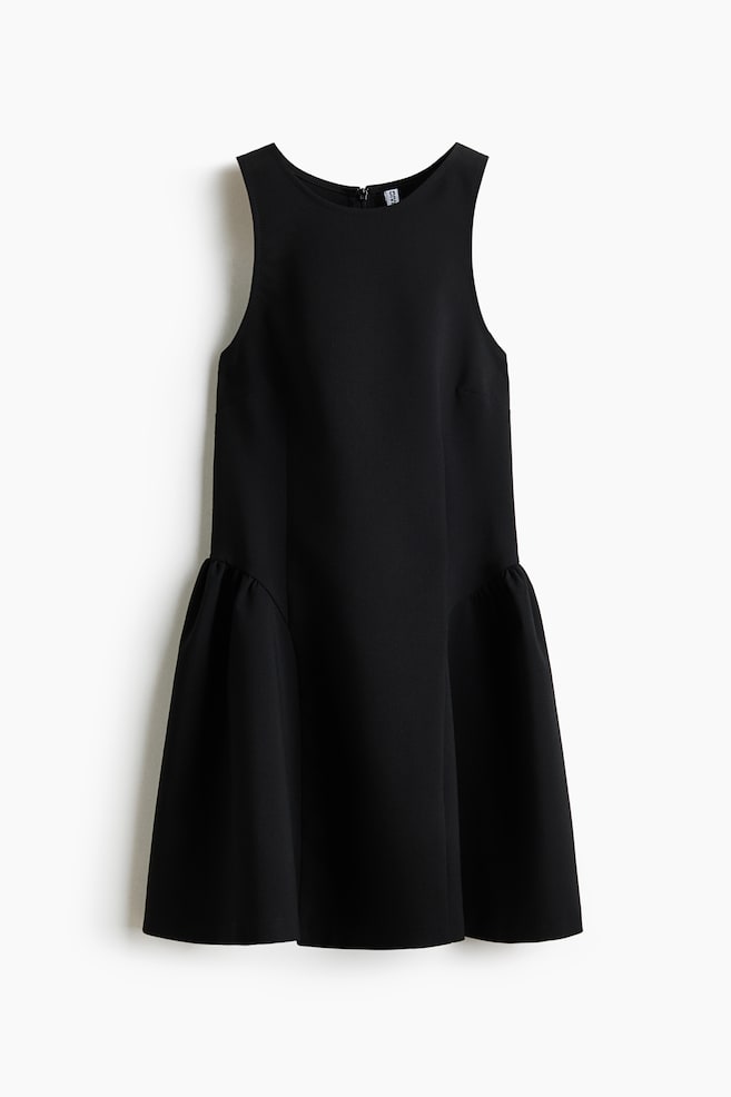Une robe noire sans manches présente un col rond et une silhouette droite à l'avant, se transformant en un volant froncé à l'ourlet. - 1