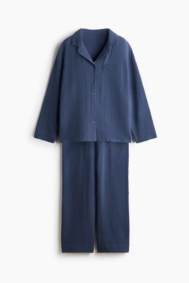 Blue pajama set featuring a long-sleeved shirt with a collar, button front, and single chest pocket, paired with matching long pants. The entire set showcases a crinkled texture, presented from the front. - 1