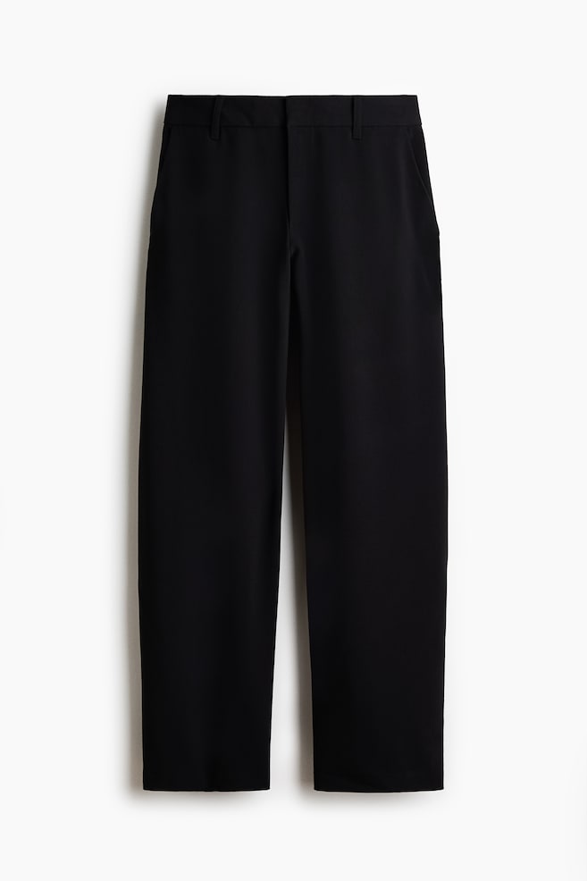 Pantalones negros mostrando su vista frontal, con una pretina plana con trabillas para cinturón y bolsillos laterales de costura vertical. Los pantalones están diseñados con una pierna recta. - 1